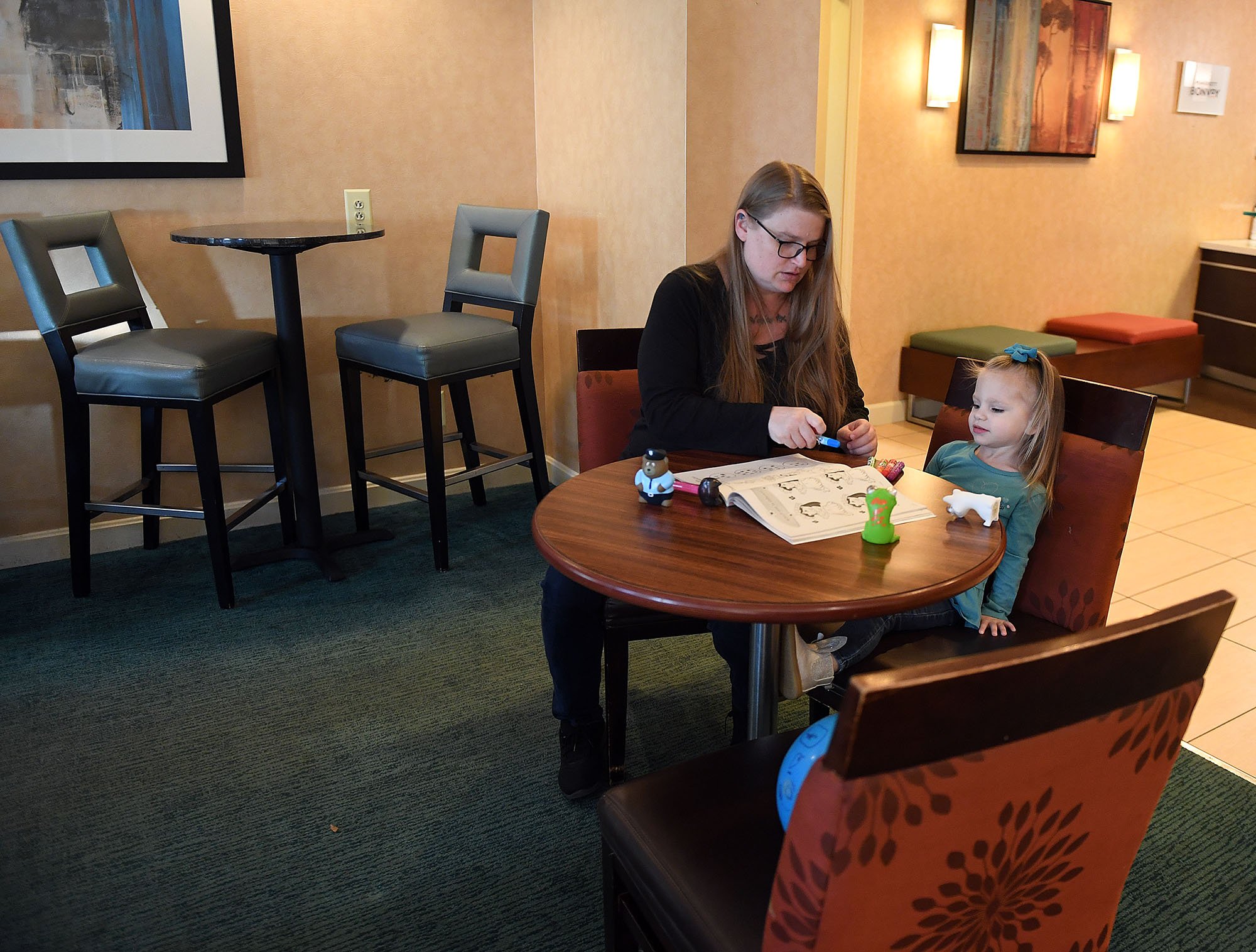  Valarie Levy colors with her daughter Azrielle, 2, in the lobby of the Residence Inn Mystic on Wednesday, November 2, 2022. With no playground they can walk to Valarie struggles to keep the active toddler entertained in a hotel room. The two have be