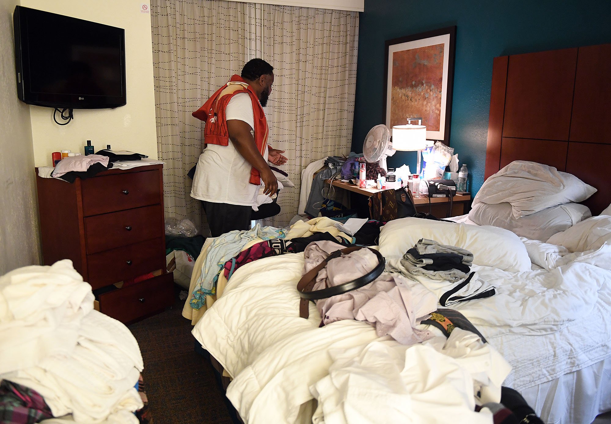  Lester Harris Sr. points out storage issues in the bedroom at the Residence Inn Mystic in Groton Monday, October 31, 2022. He and his wife Latasha Fisher-Harris along with family members have been staying at hotels since they had to leave their apar