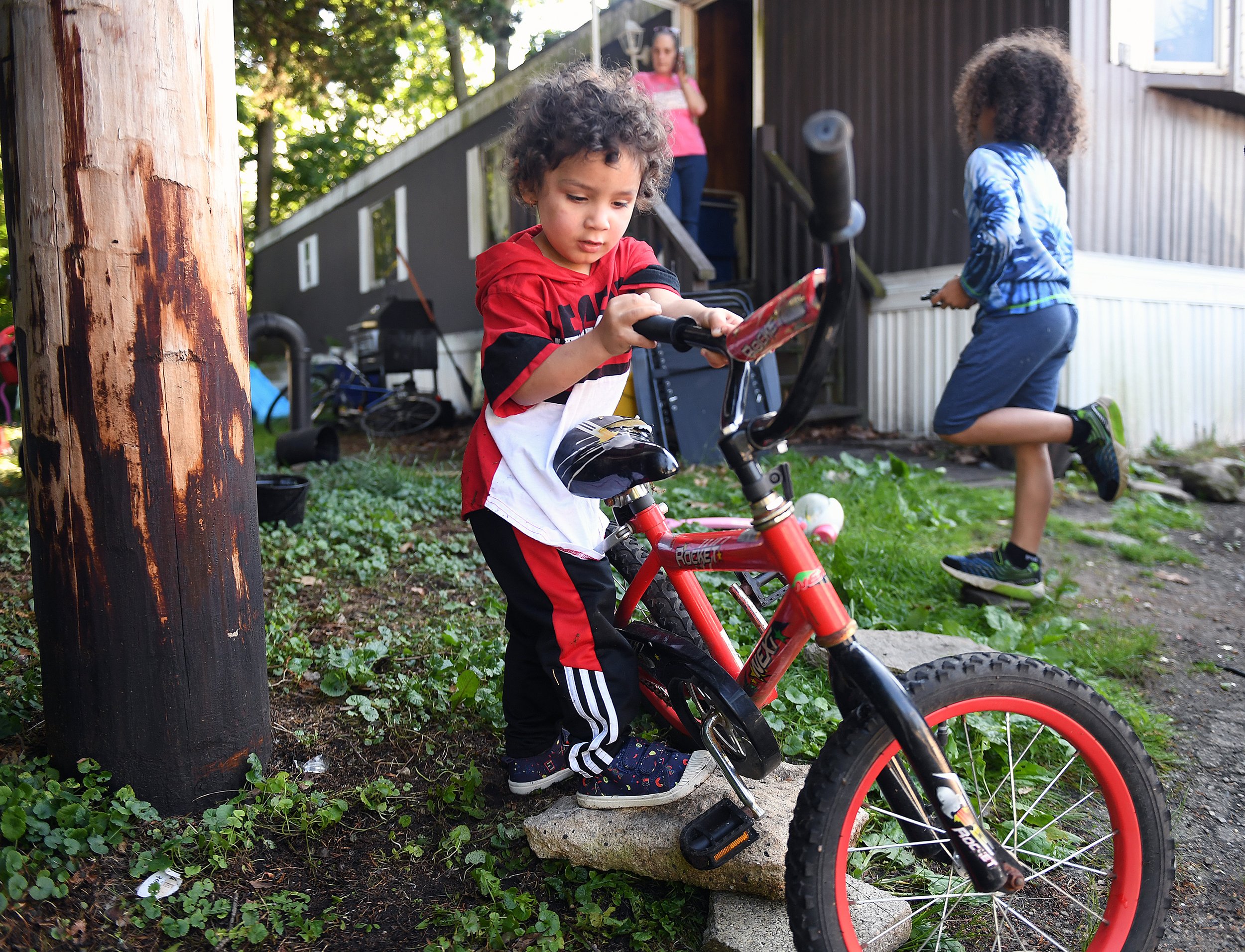  Emerson Valero plays with a bike outside his home in Groton on Wednesday, June 22, 2022.  His mother Aleshia Valero, who lived at New London’s Crystal Avenue High Rises just before they closed, now lives in a two-bedroom trailer she owns with her fo