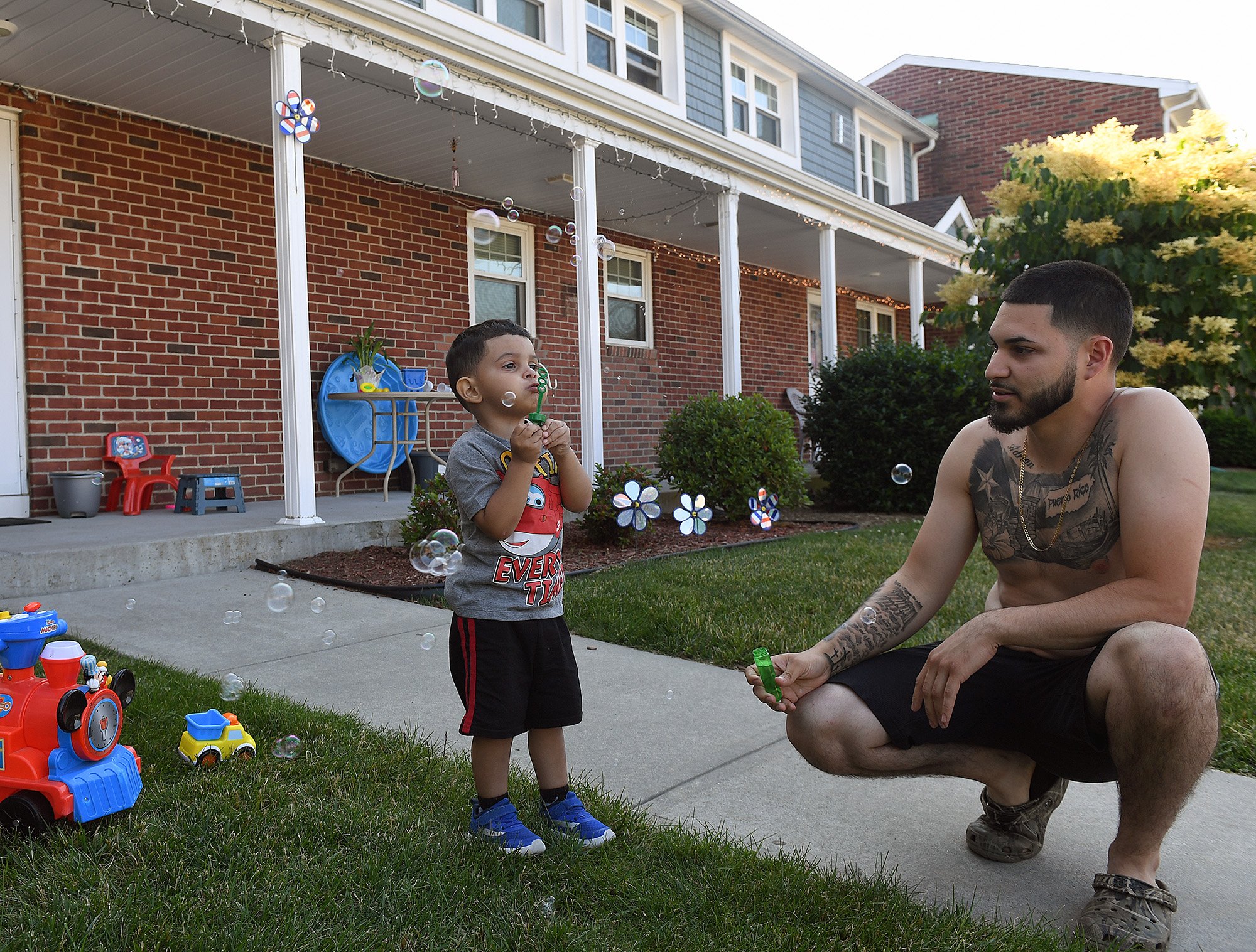  Yadiel A. Reyes looks on as his son Adrian A., 2, blows bubbles outside his mother Yesenia Nieves’ Carabetta apartment in New London Monday June 20, 2022. The family has lived there for 14 years.“We were just sitting out here talking about buying a 