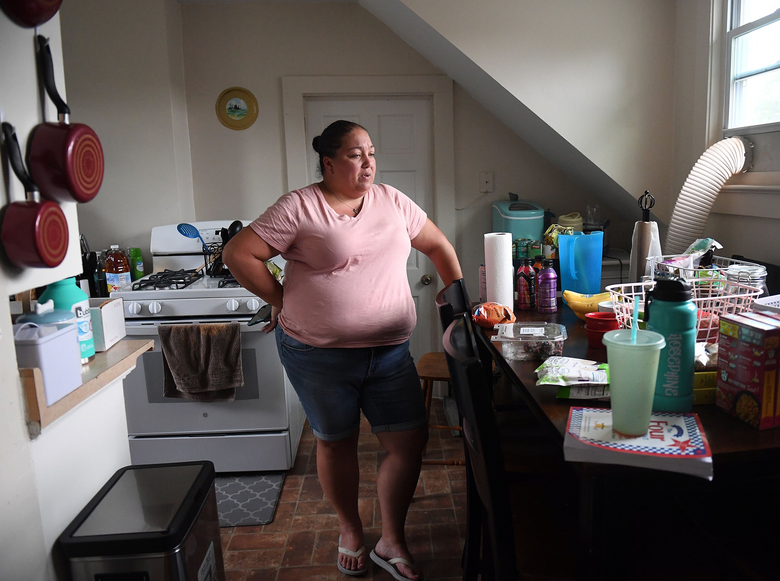  Josephine Suarez talks about storage issues in her kitchen  at her apartment in Norwich Monday, August 8, 2022. She shares a three-bedroom with two of her daughters and worries she may have to move after her landlord sells the building.  (Sarah Gord