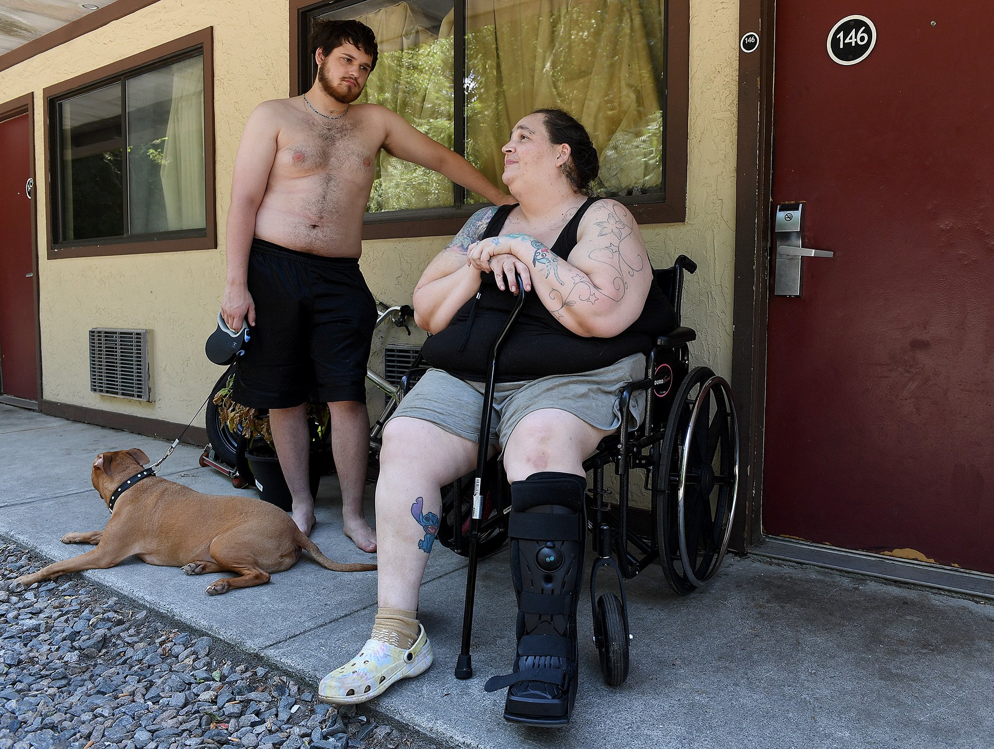  Sabrina Babey talks with her son Mike Roy, 18, and their dog Harmony outside their room at the Red Roof Inn in New London on Tuesday, August 9, 2022. The two have lived with her fiancé William Waddicor, two dogs and a cat for over two years and they