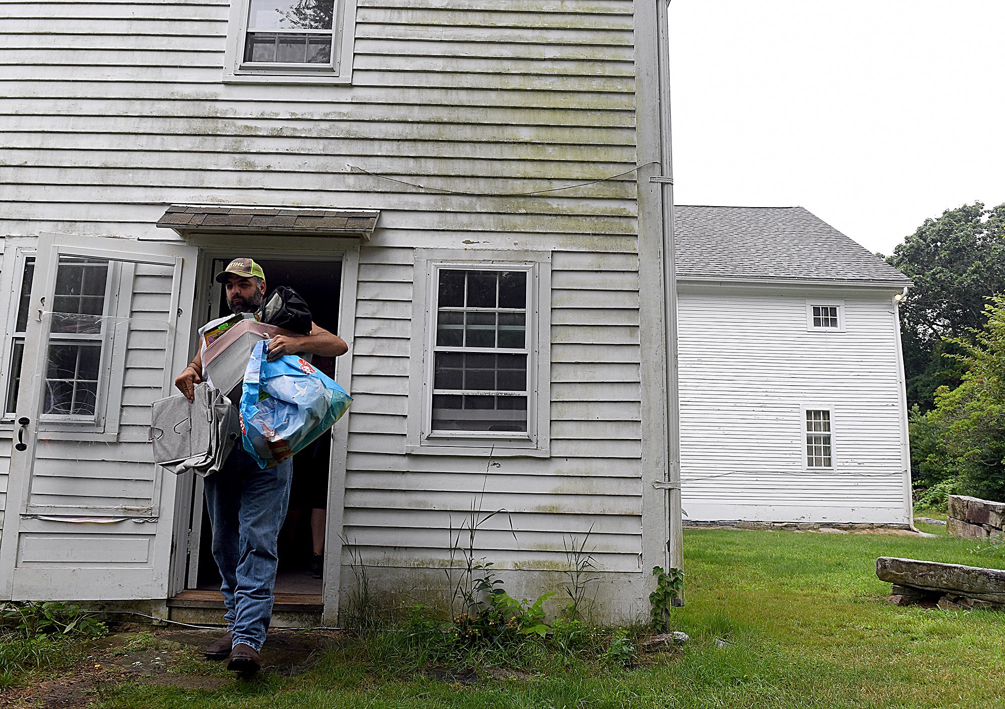  Corey Watford carries packed belongings as his family moves out of their home in Ledyard Monday, July 18, 2022.  His wife Rebecca Lindner is the caretaker of Nathan Lester House where they live and all of her children have had elevated lead levels a