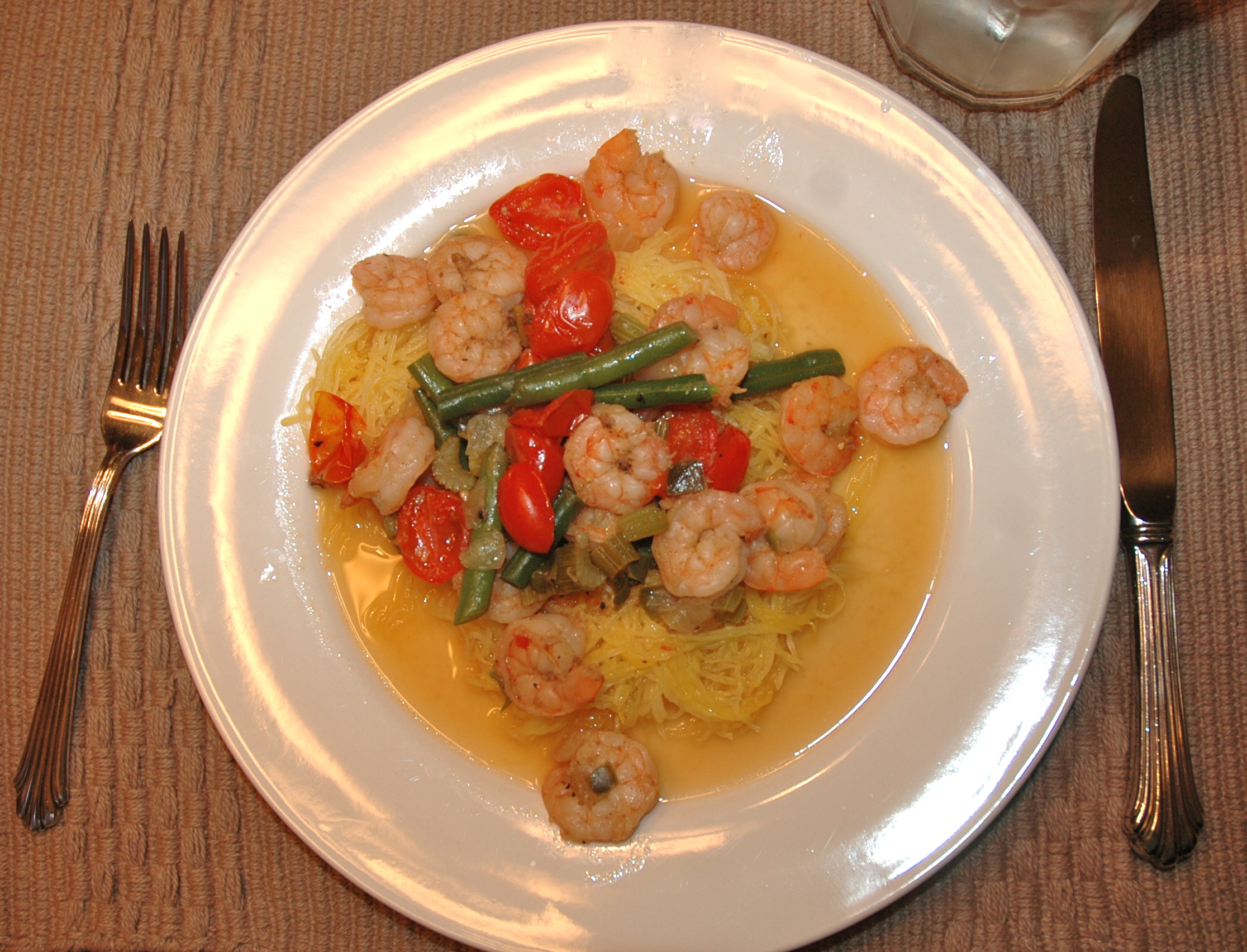 Shrimp on a set of spaghetti squash and veggies in clarified butter sauce. 