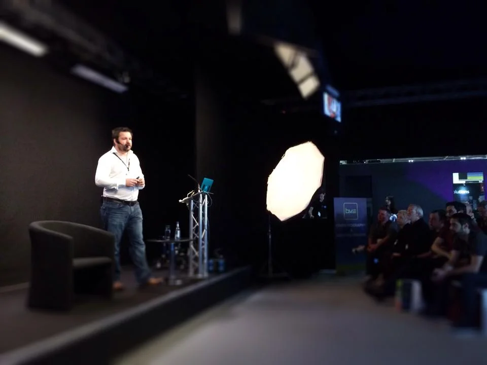 Den on stage sharing with filmmakers about how to get more clients