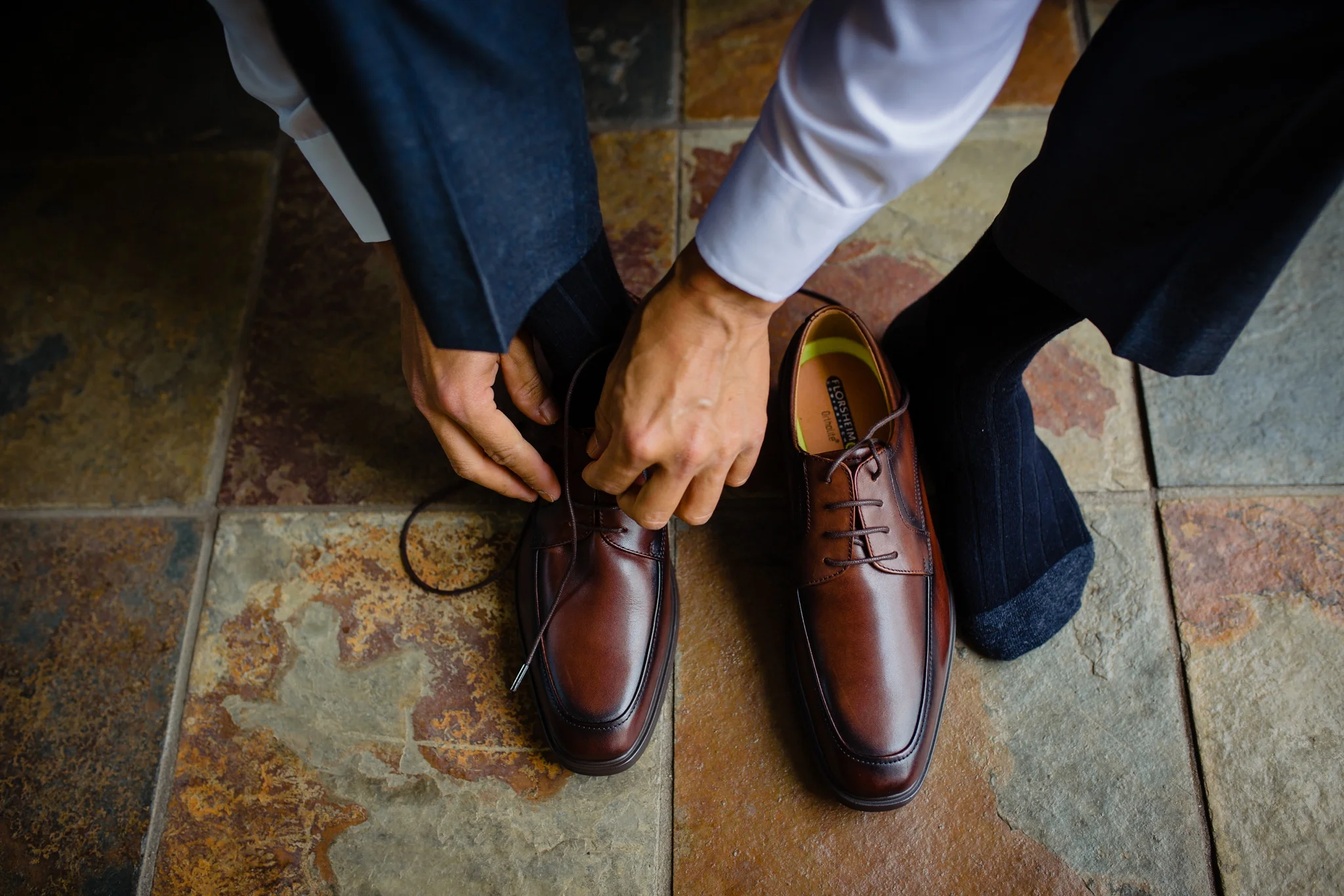 groom putting on his shoes at his wedding day at the westin hapuna