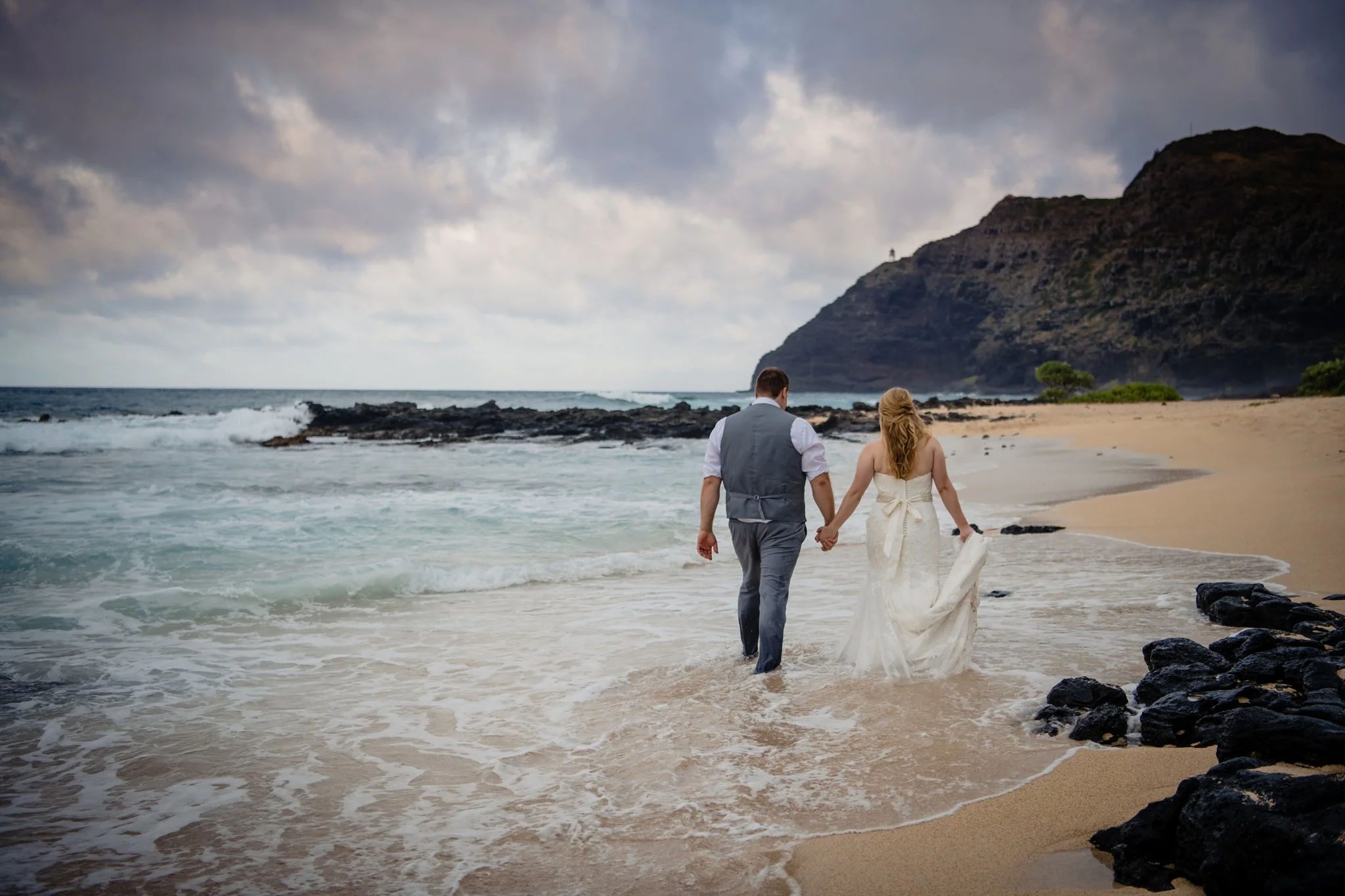newly married couple walking on a beach in Oahu