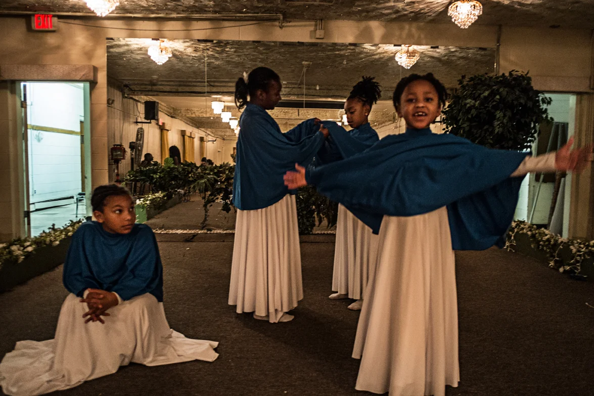 Downstairs in the rehearsal room, Emma and her friends preparing before performing for the Sunday service.
