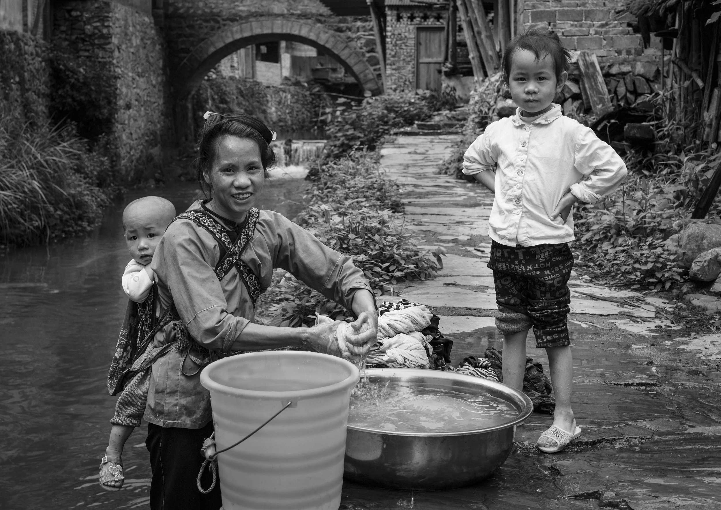 Yan aged 30 washes the families clothing in the stream near her home
