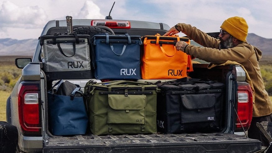 a man packing a pickup with RUX 70 litre boxes
