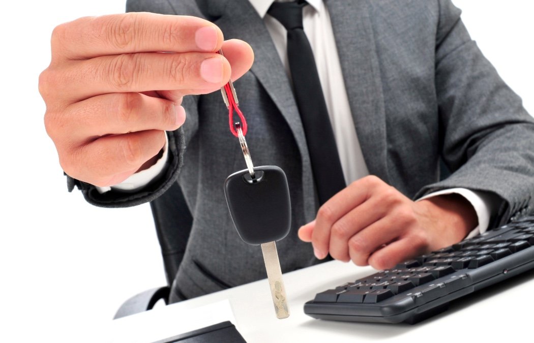 a man in a suit handing over a  car key