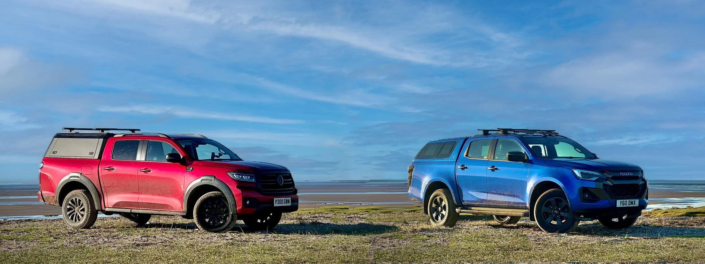 A red  GWM POER300 and a blue Isuzu D-Max together on a beach