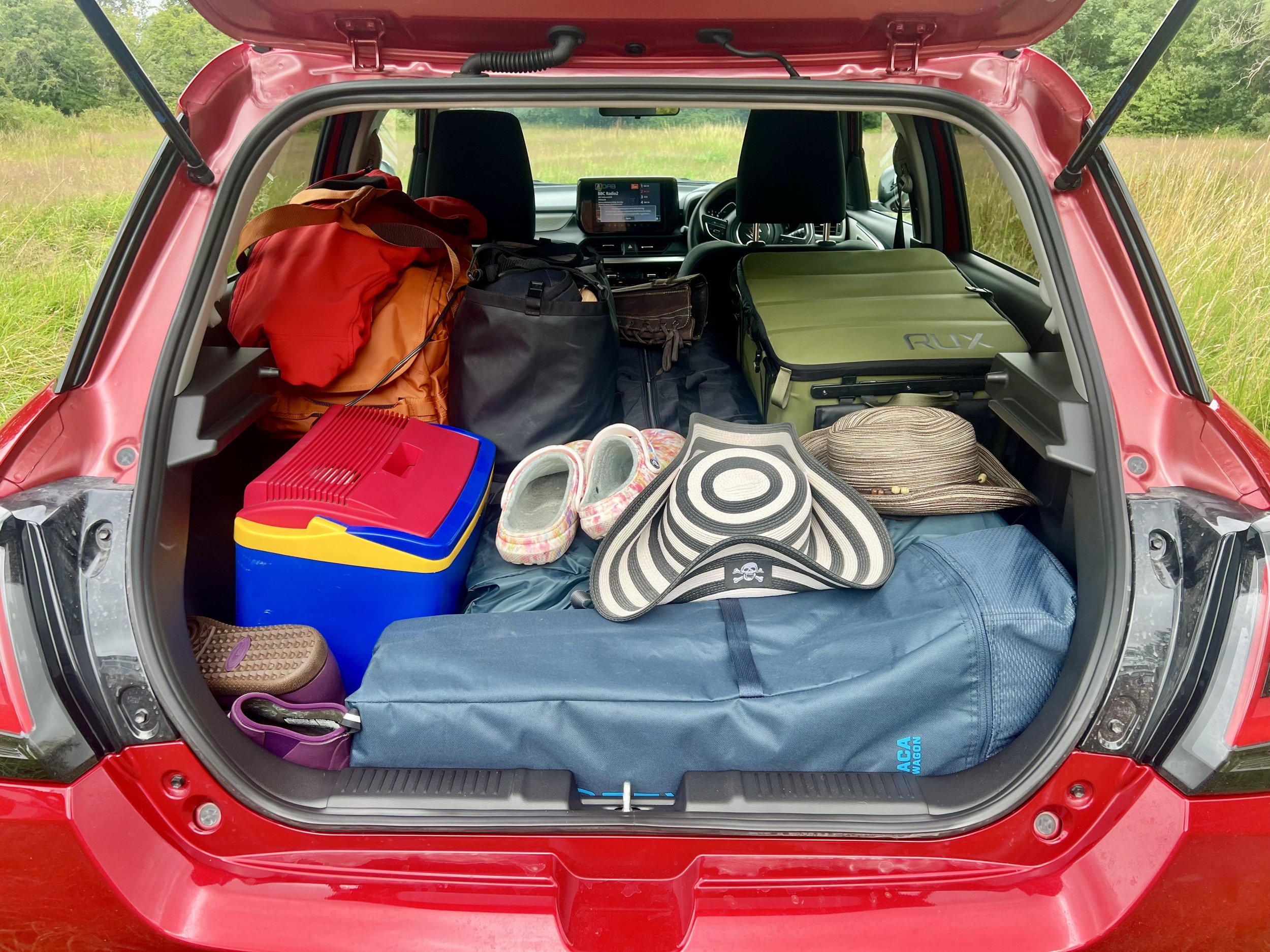 A car packed with lots of camping gear showing the Rux 70L box