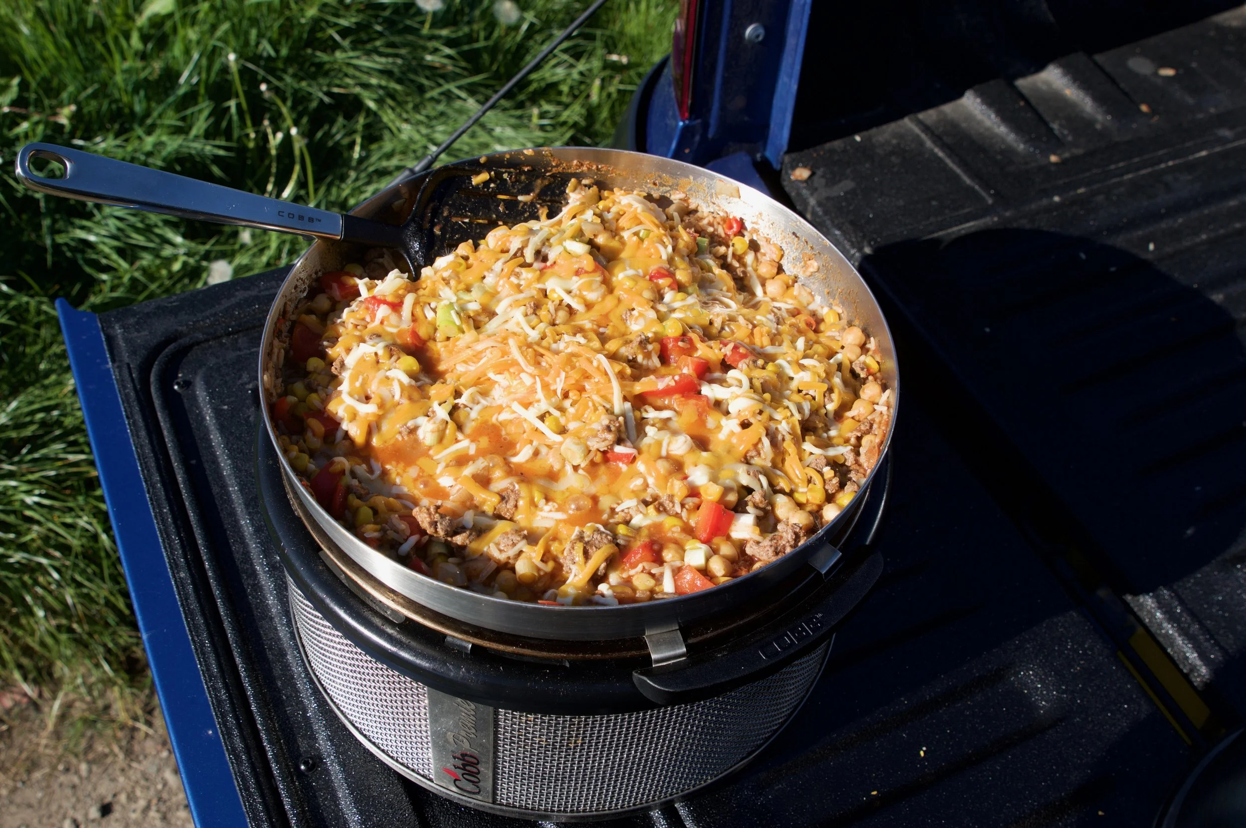 A photo of a pan with Mexican Cheesy beef inside sat on top of a COBB BBQ