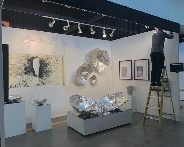 Our booth at the #LAartShow2019 while @made_x_mason adjusts the lights on the Gesture Wall Piece I. Come see us &amp; the work at Booth #906. .
Stay tuned to follow the progress of the Show!!
.
.
.
.
.
#laartshow @LAartShow @DesignIsRI #DesignisRI #D