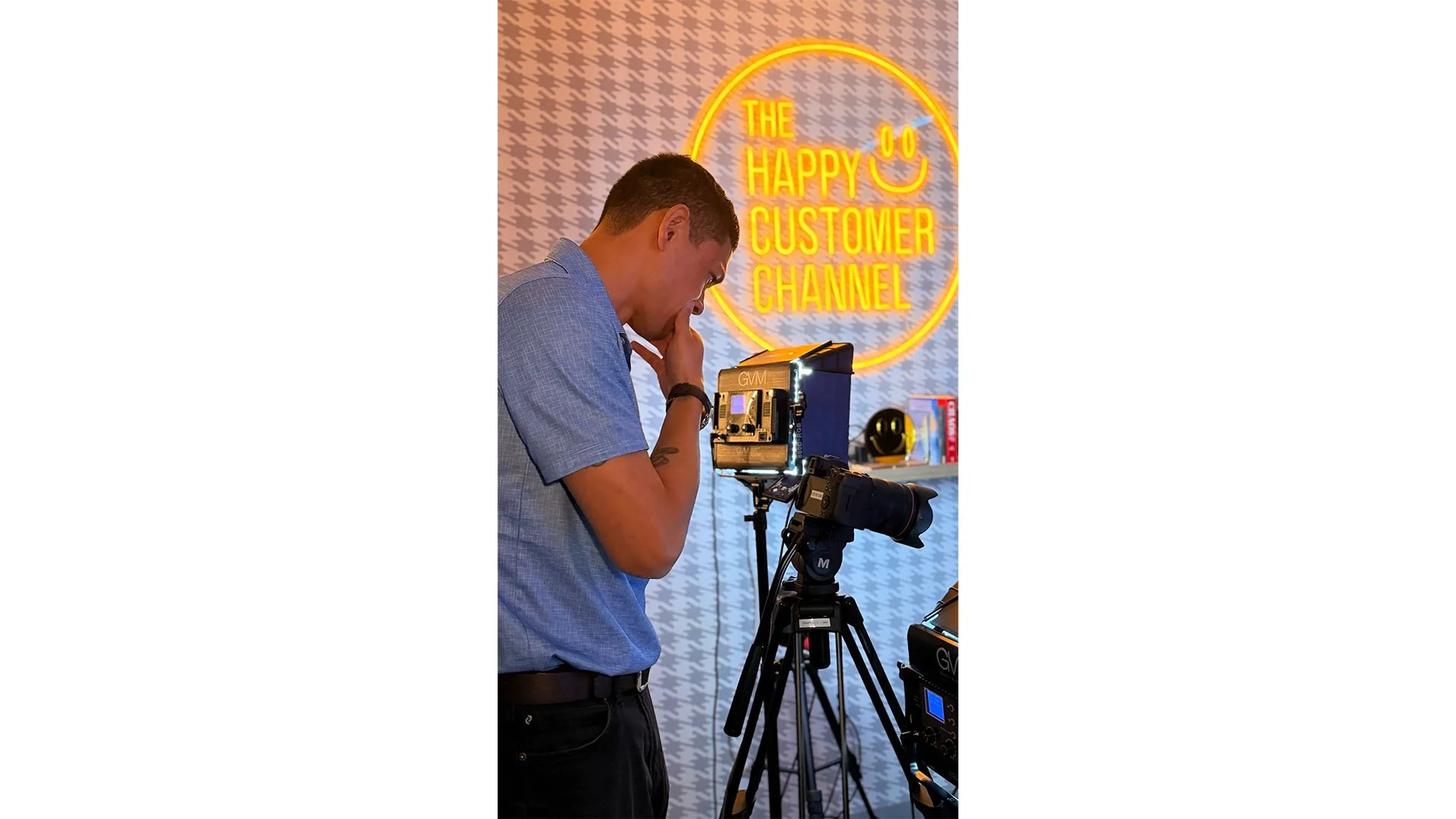 Behind-the-scenes photo of Francisco Anduiza Jr. (Franky Anduiza) setting up camera equipment in The Happy Customer Channel podcast studio during video production.