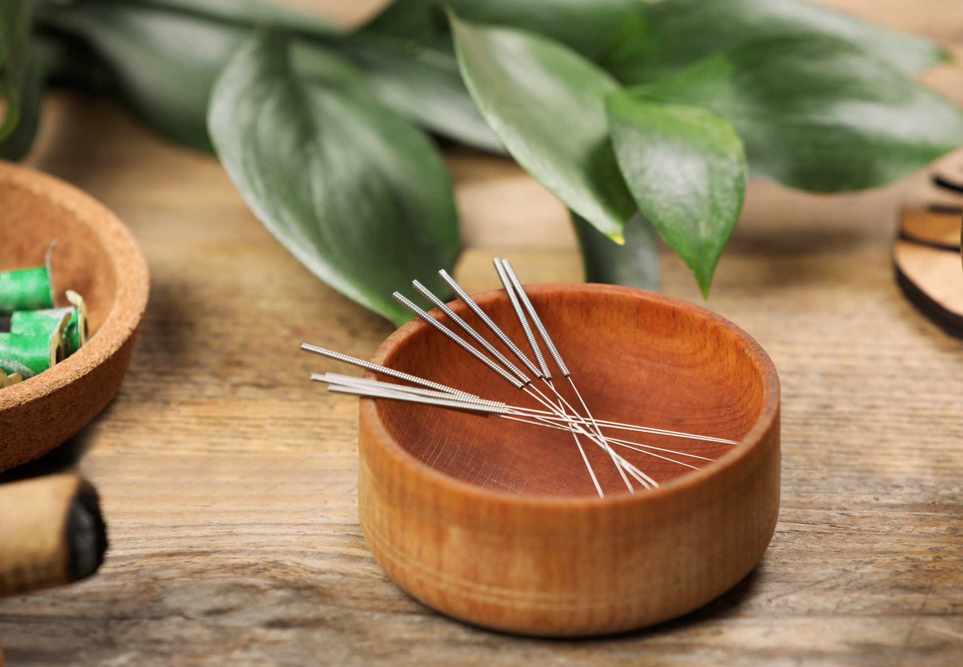 acupuncture needles in a wood bowl