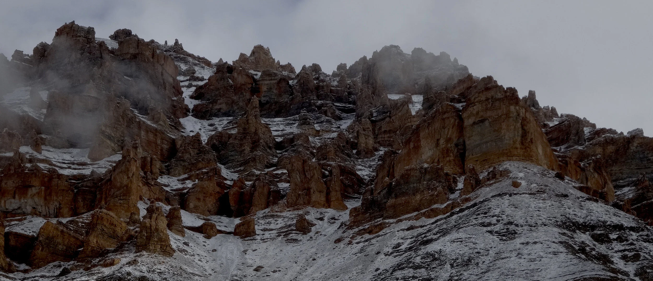 A crenellated canyon wall towers 2000m above us. Crossing the inner/outer divide to social solution spaces could be harder than climbing out through this.