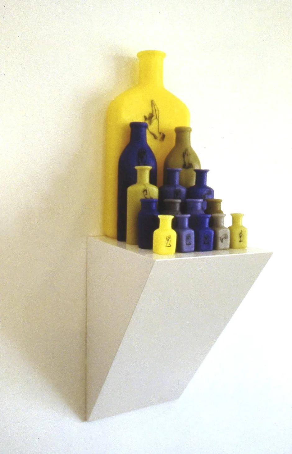 Reading is Seeing, 1999: Wax, wood, applied text/image; 25 x 9 x 7 inches. The sign language hands spell out the title of the piece.