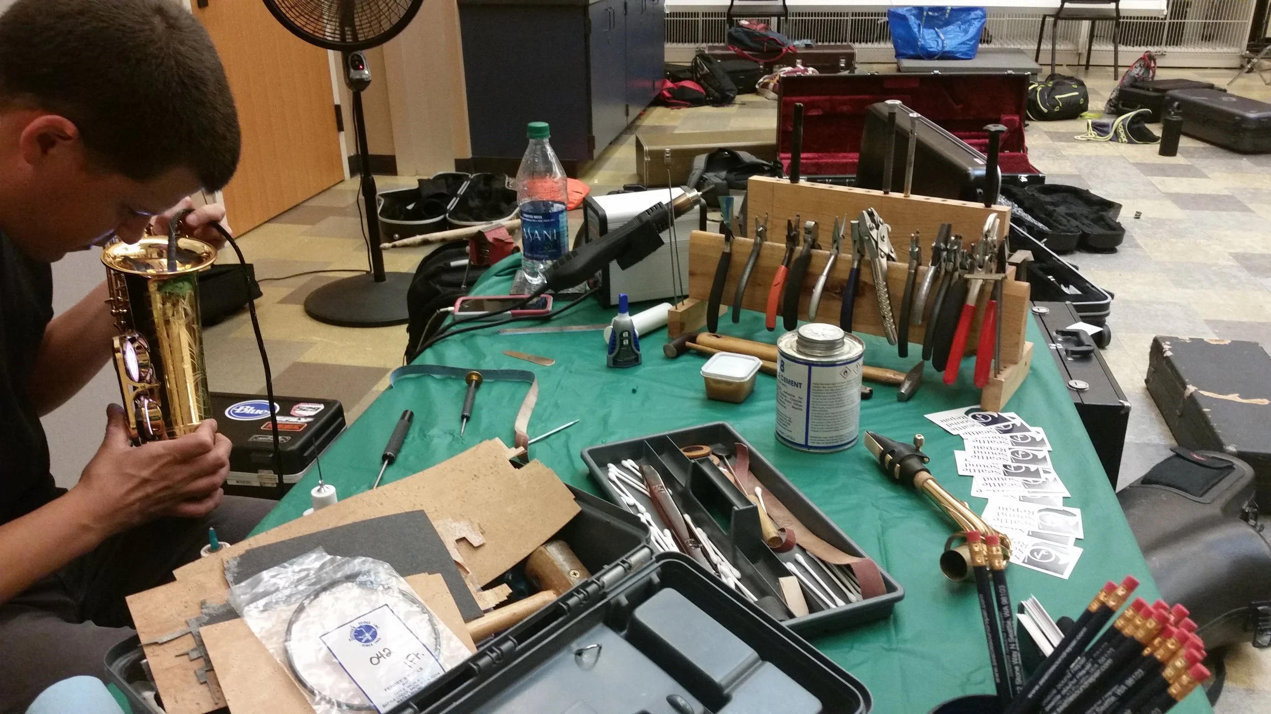 Seattle Sound Repair's Jansen Dustin performs maintenance on student saxophones.