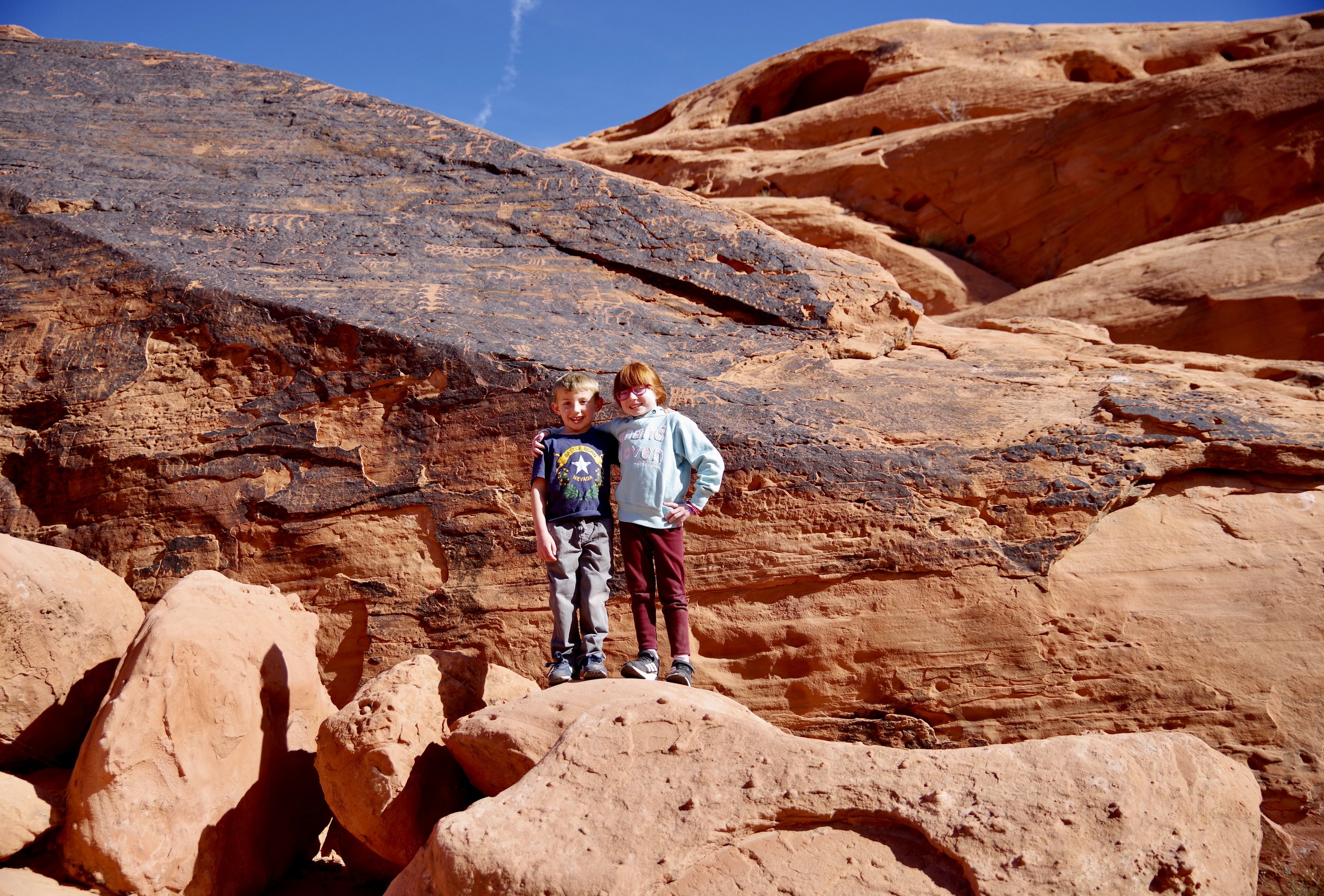 The kids in front of the same petroglyphs