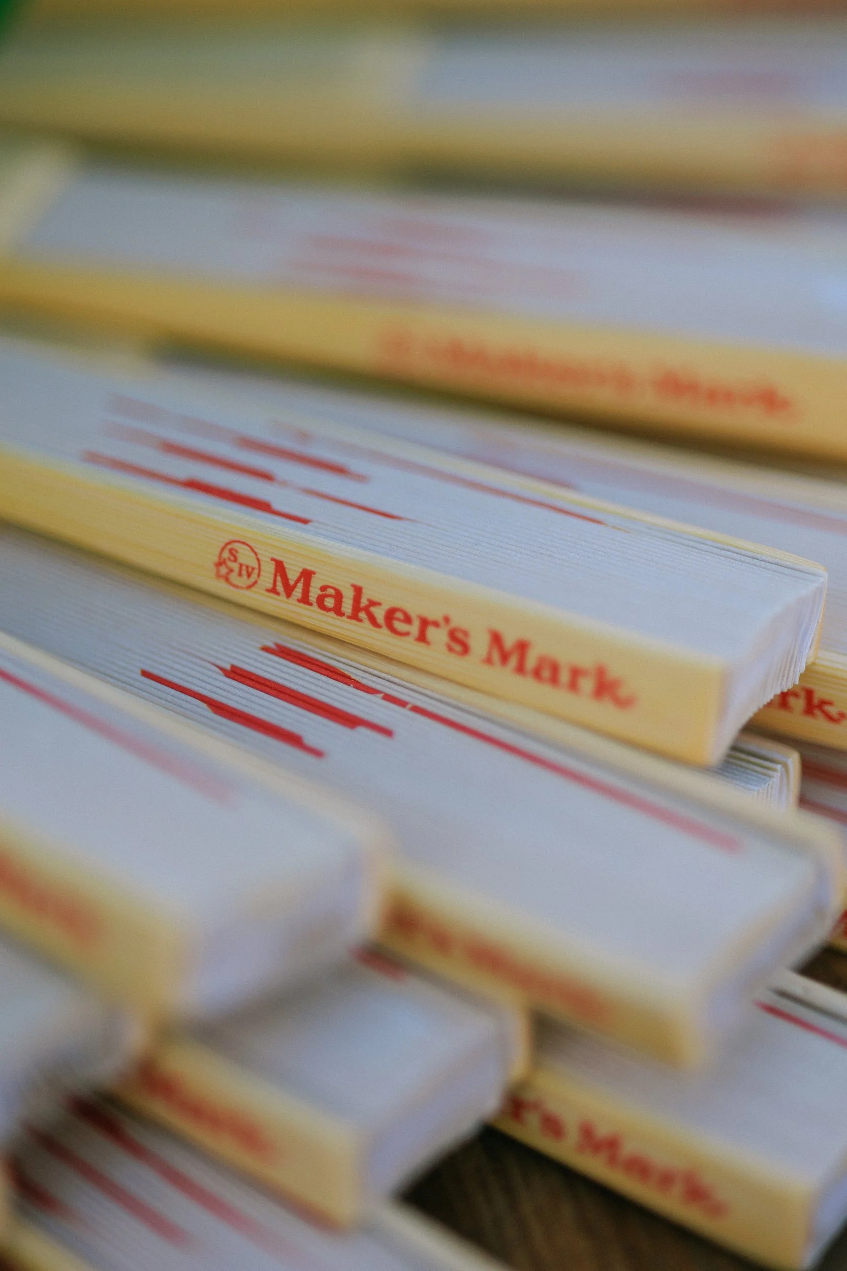 Close-up of multiple packs of Maker's Mark matches stacked together, with the brand's logo and red wax seal symbol visible.