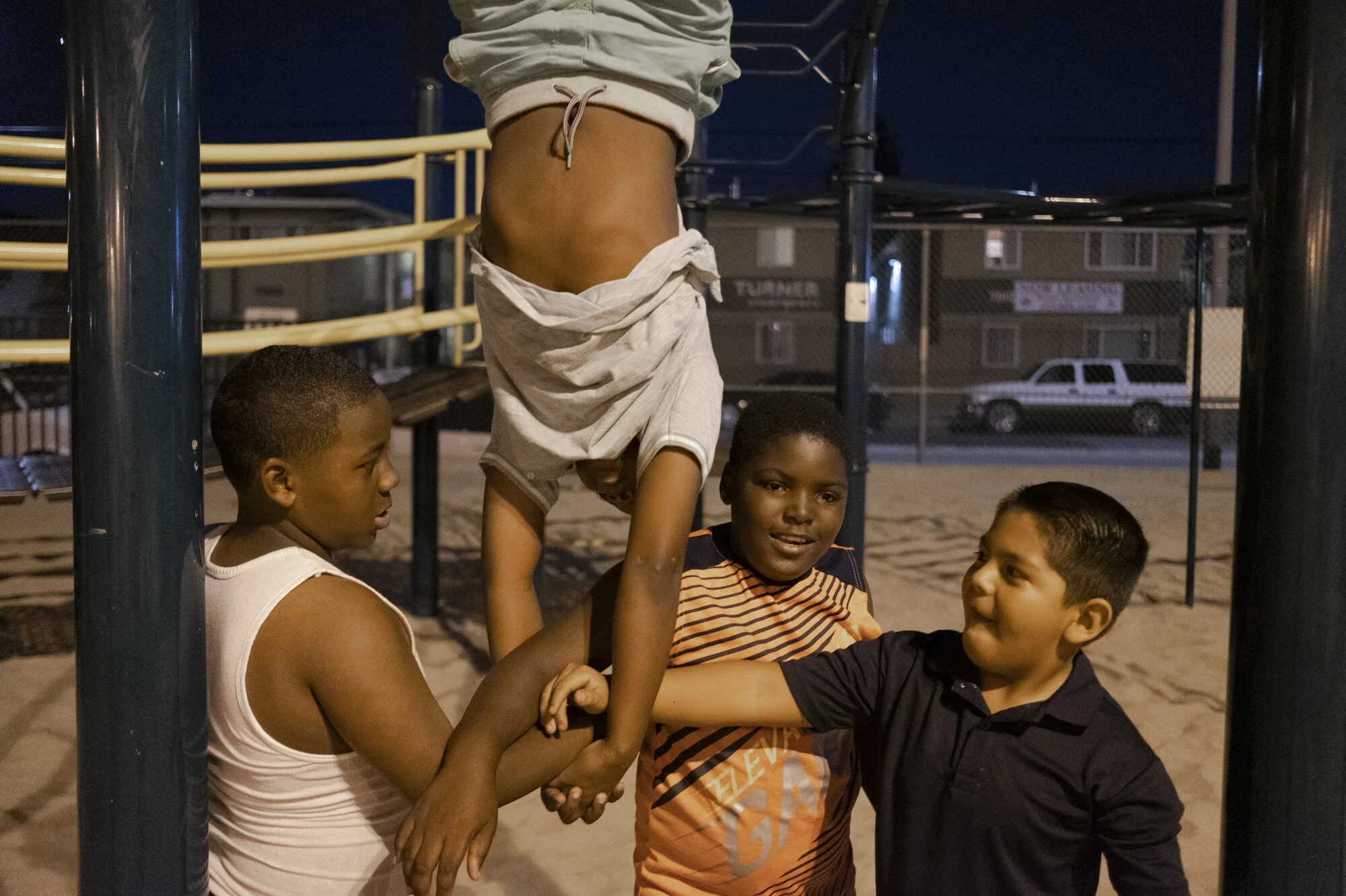  Jmauriaughn Rayne, 10, hangs upside down and links arms with his friends.  