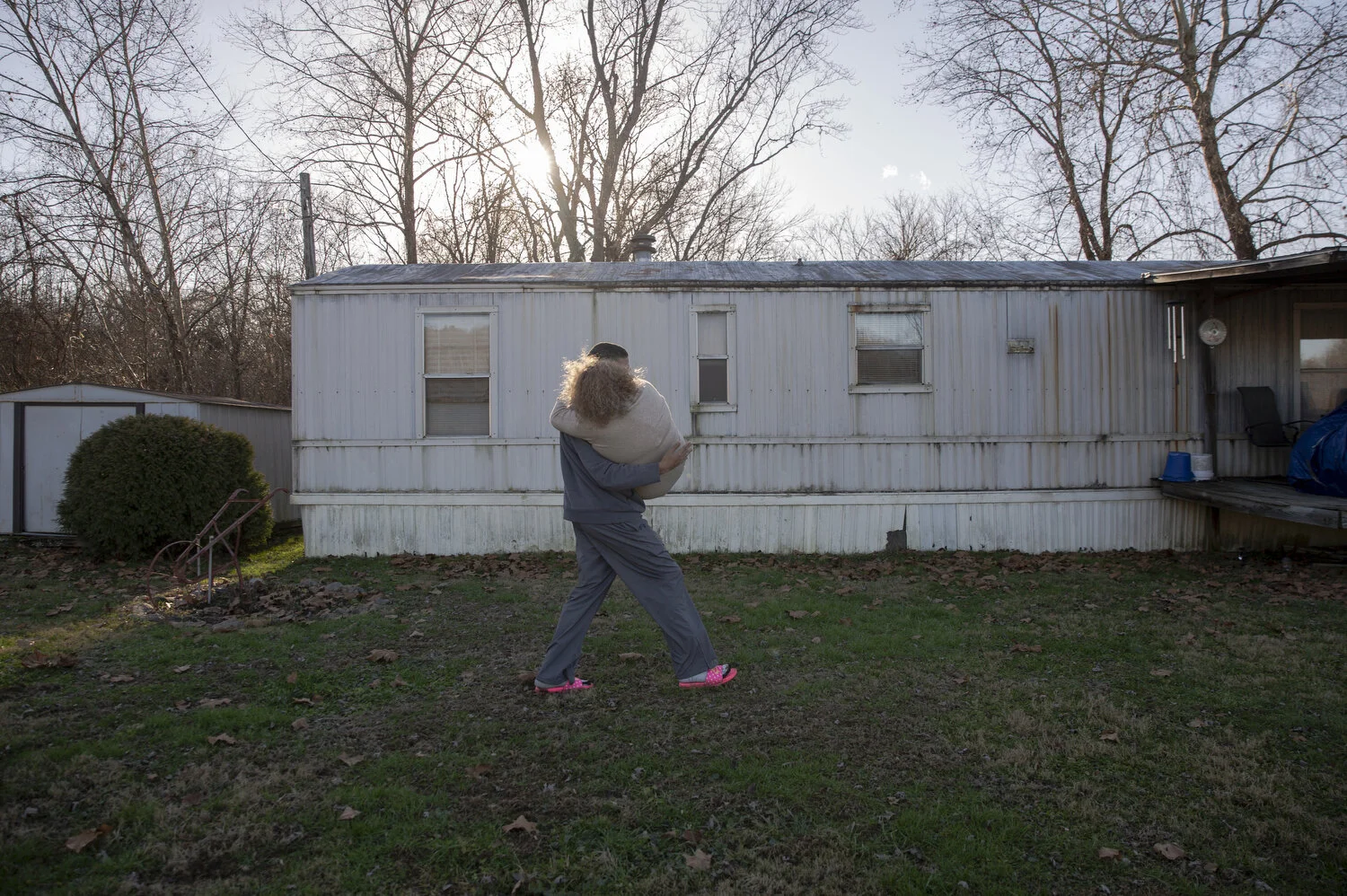  Mr. Byrd carries then-girlfriend Isis Mayle, 17, across his yard in Millfield, Ohio.  