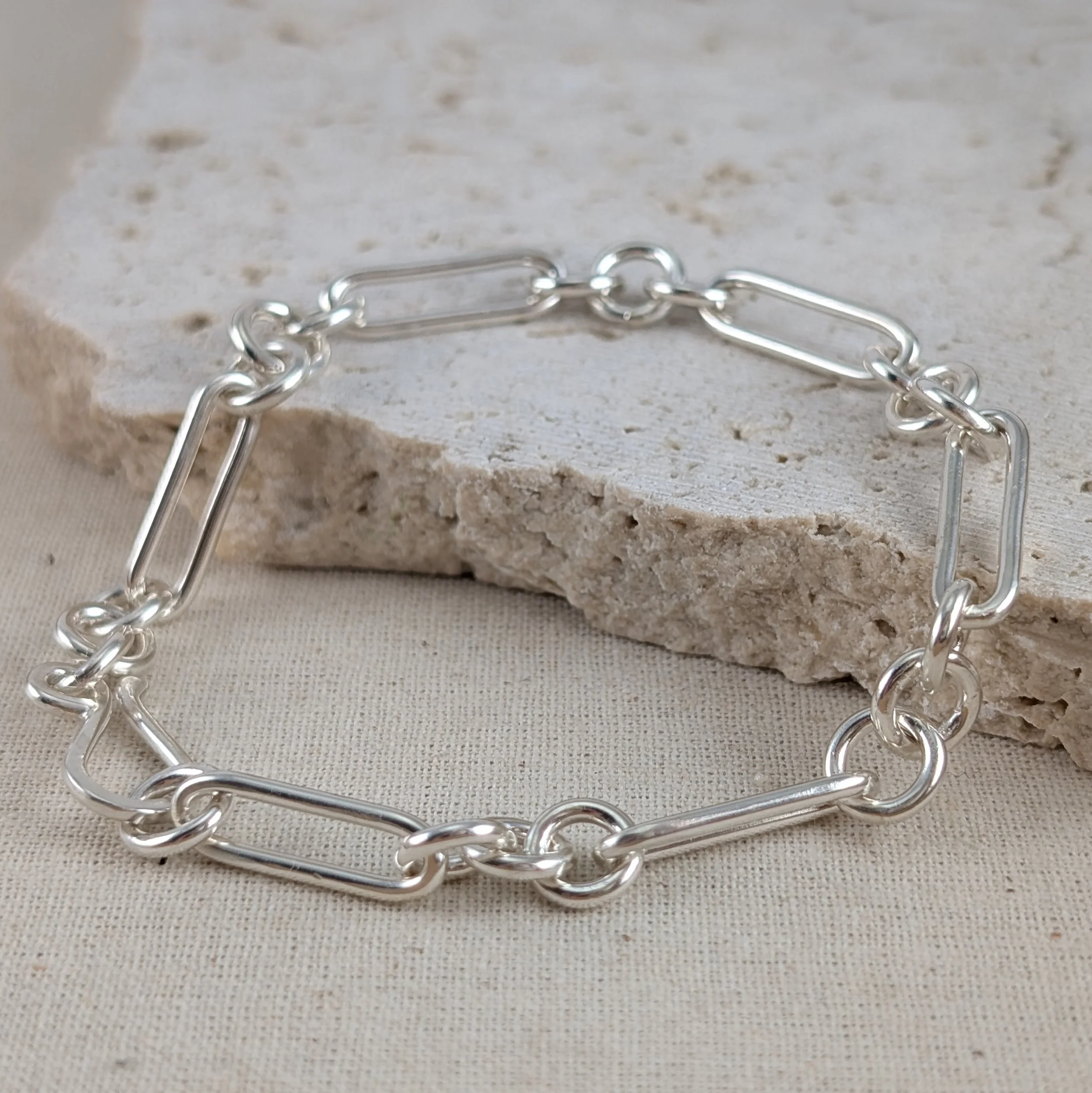 Close-up of a matte Argentium sterling silver figaro bracelet with elongated paperclip links and an S-shaped catch by Georgina Dunn Jewellery.