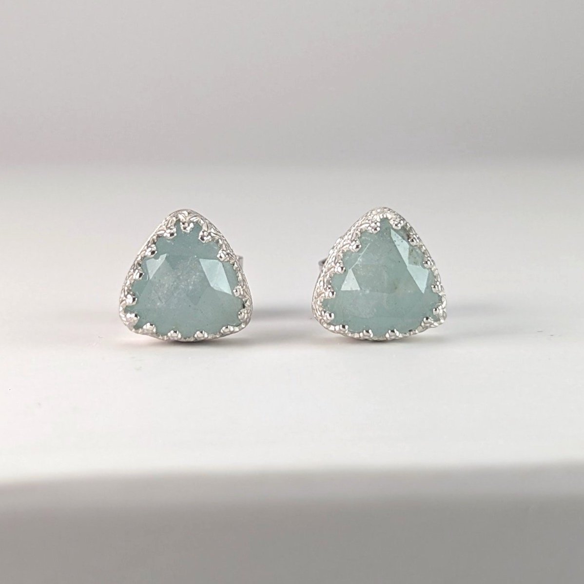 Triangular milky aquamarine studs with decorative setting