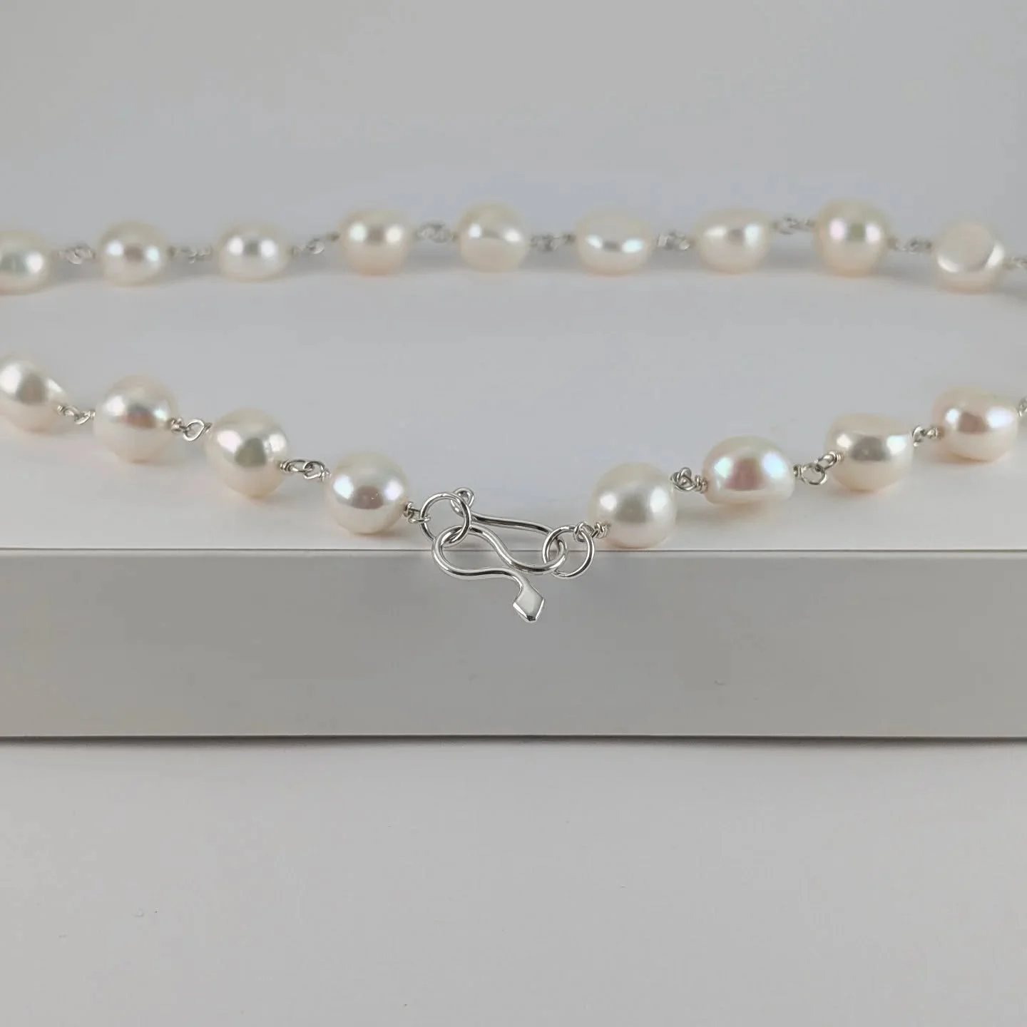 This snake catch button shaped freshwater pearl necklace was listed on my website today. I use fine silver wire between the pearls and the snake is made with Argentium sterling silver 940. 

It's good to be getting things up for you all to see and en