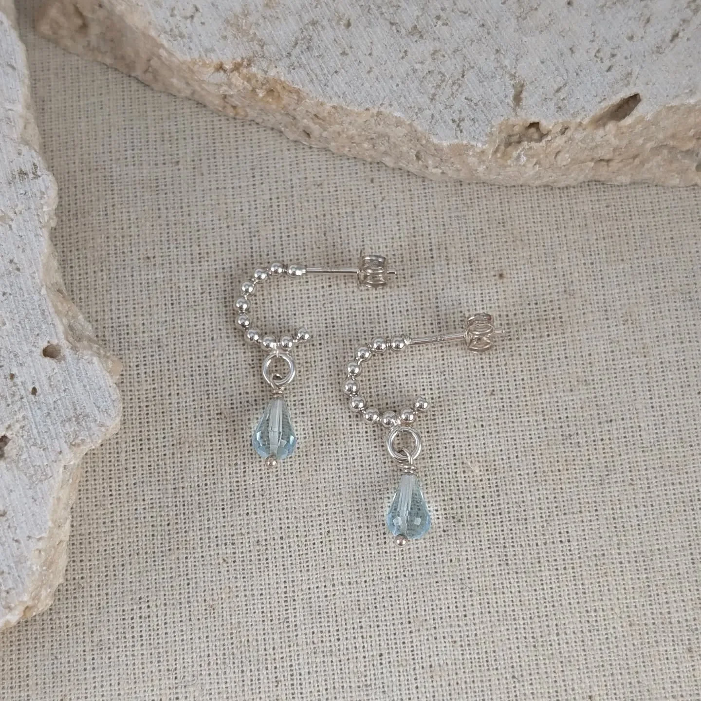This tiny pair of beaded wire hoops feature a pair of gorgeous face cut aquamarine beads. Very elevated and stylish making them perfect to lift your outfit to the next level. Great with a simple white dress and some stacking necklaces. 

Check out my