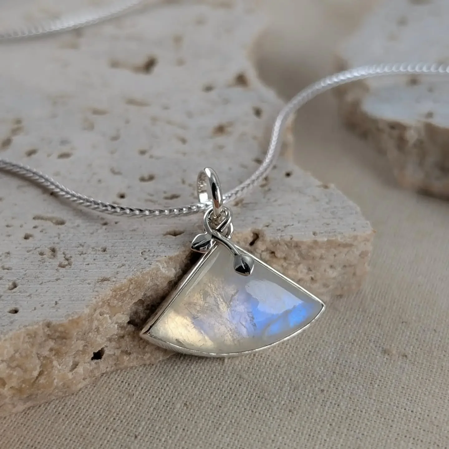 I've added a few photos of this pendant to try to capture the colours that flash within it. This is rainbow moonstone which is commonly just called moonstone these days. Did you know that this is a type of white labradorite? This pendant is set in Ar