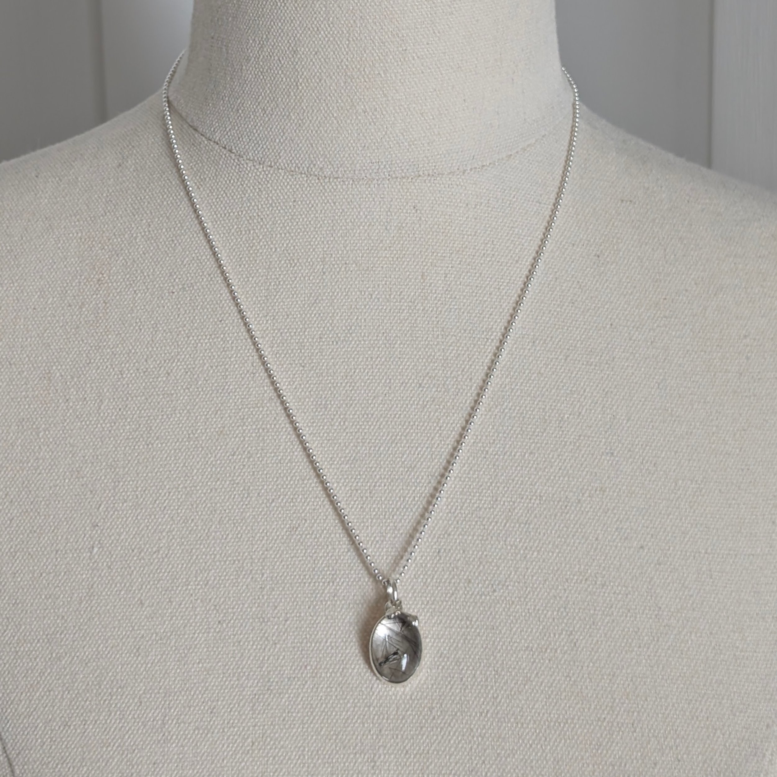 Rutile Quartz Pendant with Leaves on Ball Chain Necklace shown on calico mannequin zoomed out to show length