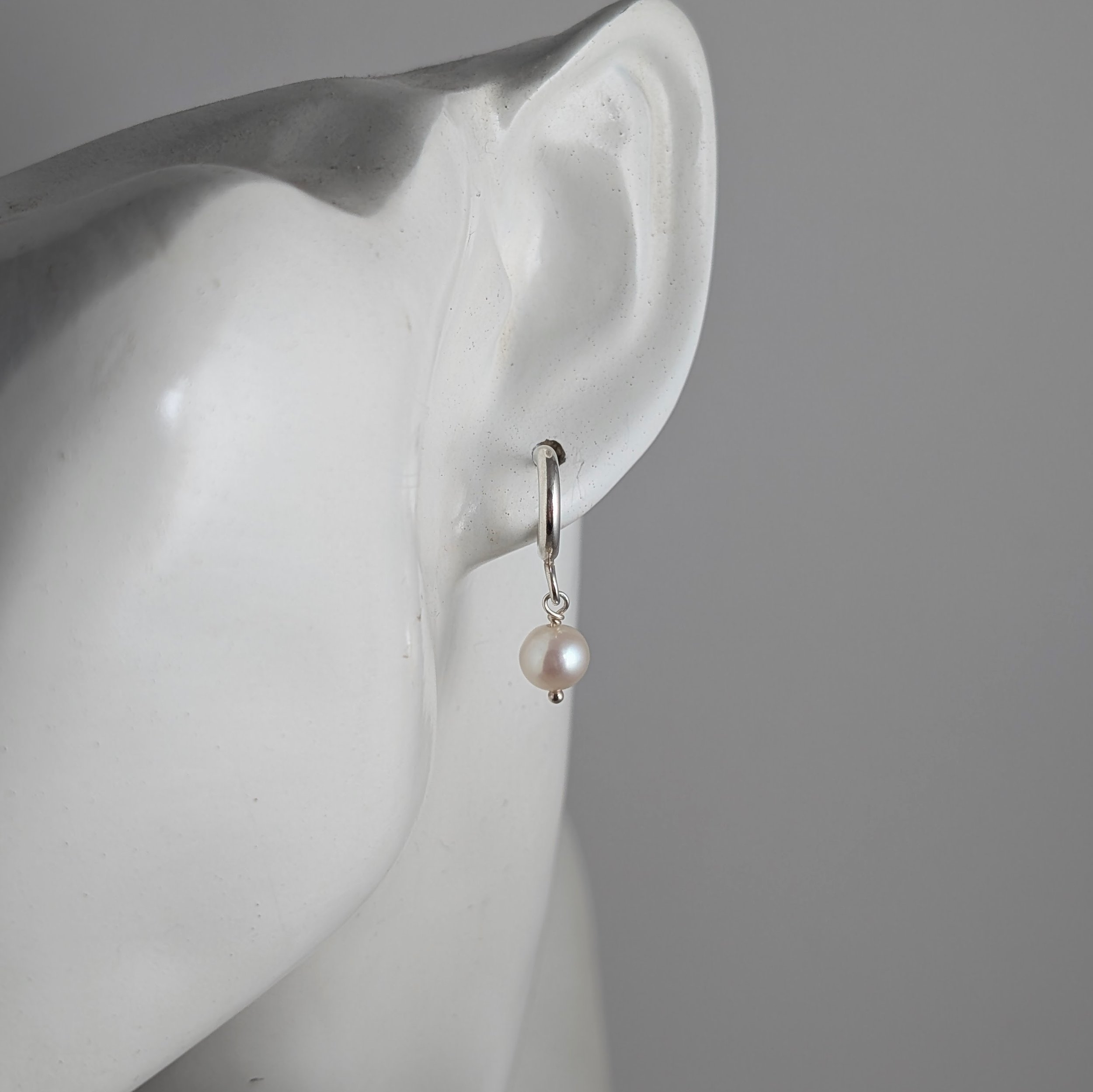 Tiny-2mm-hoops-with-white-oval-pearls-on-ear.jpg