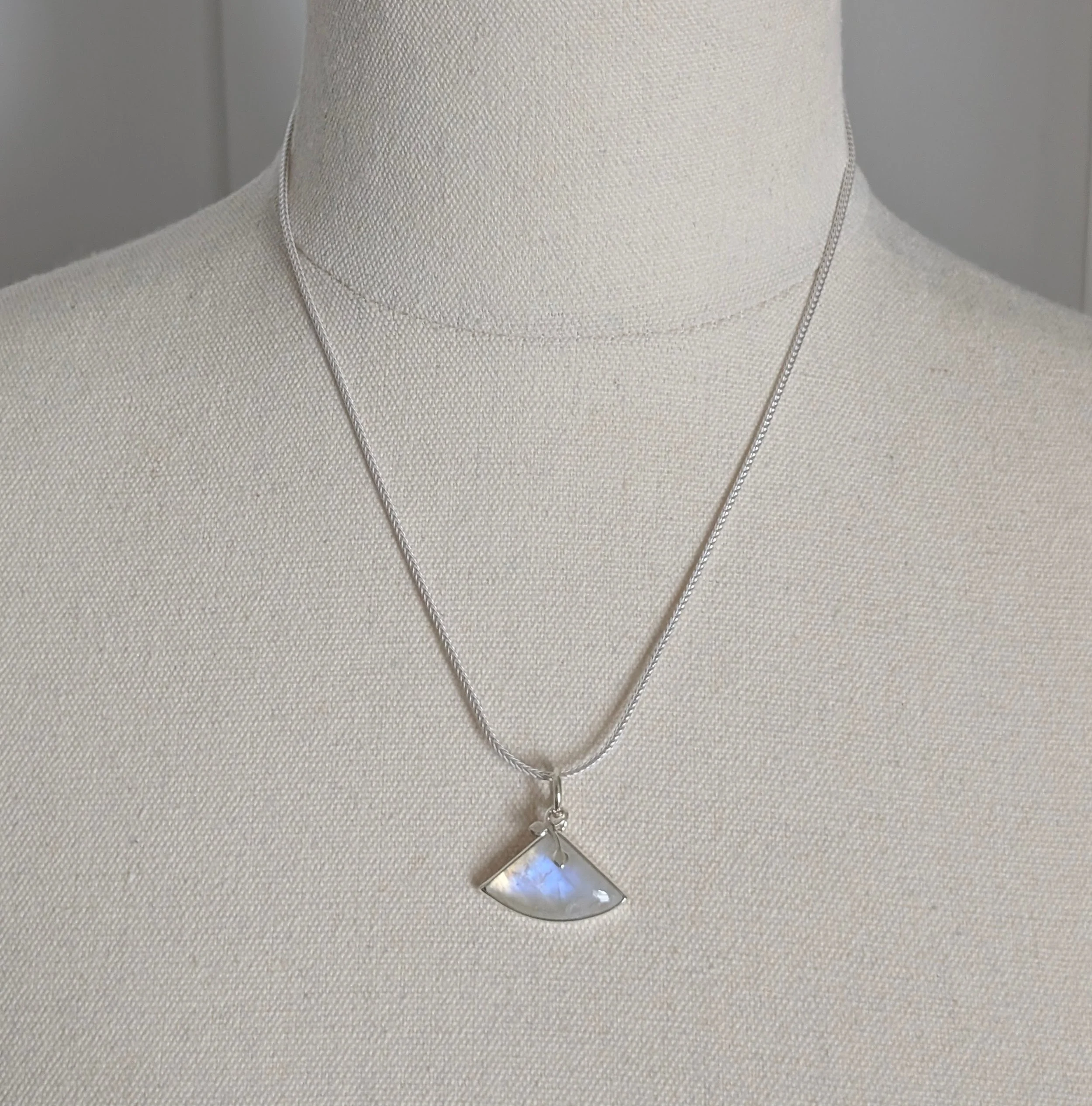Fan-shaped moonstone pendant on sterling silver foxtail chain shown on mannequin