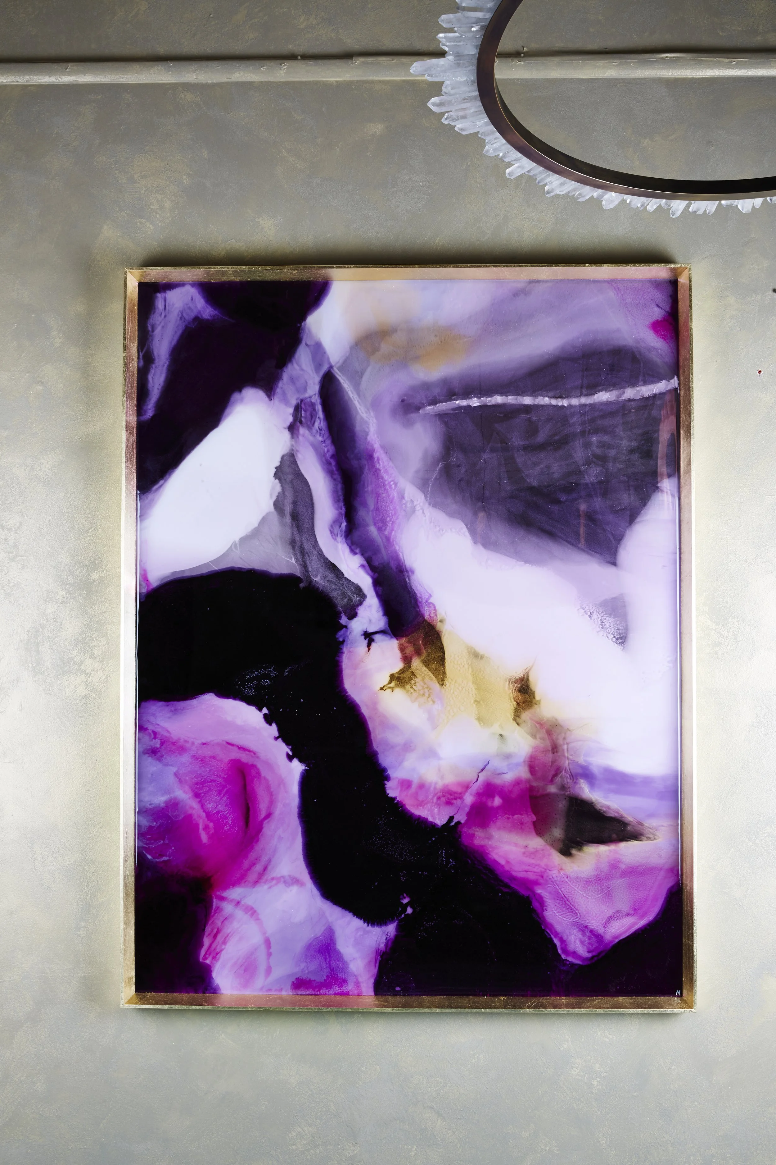 Abstract purple, black, white, and yellow swirled painting or print framed and hanging on a wall.