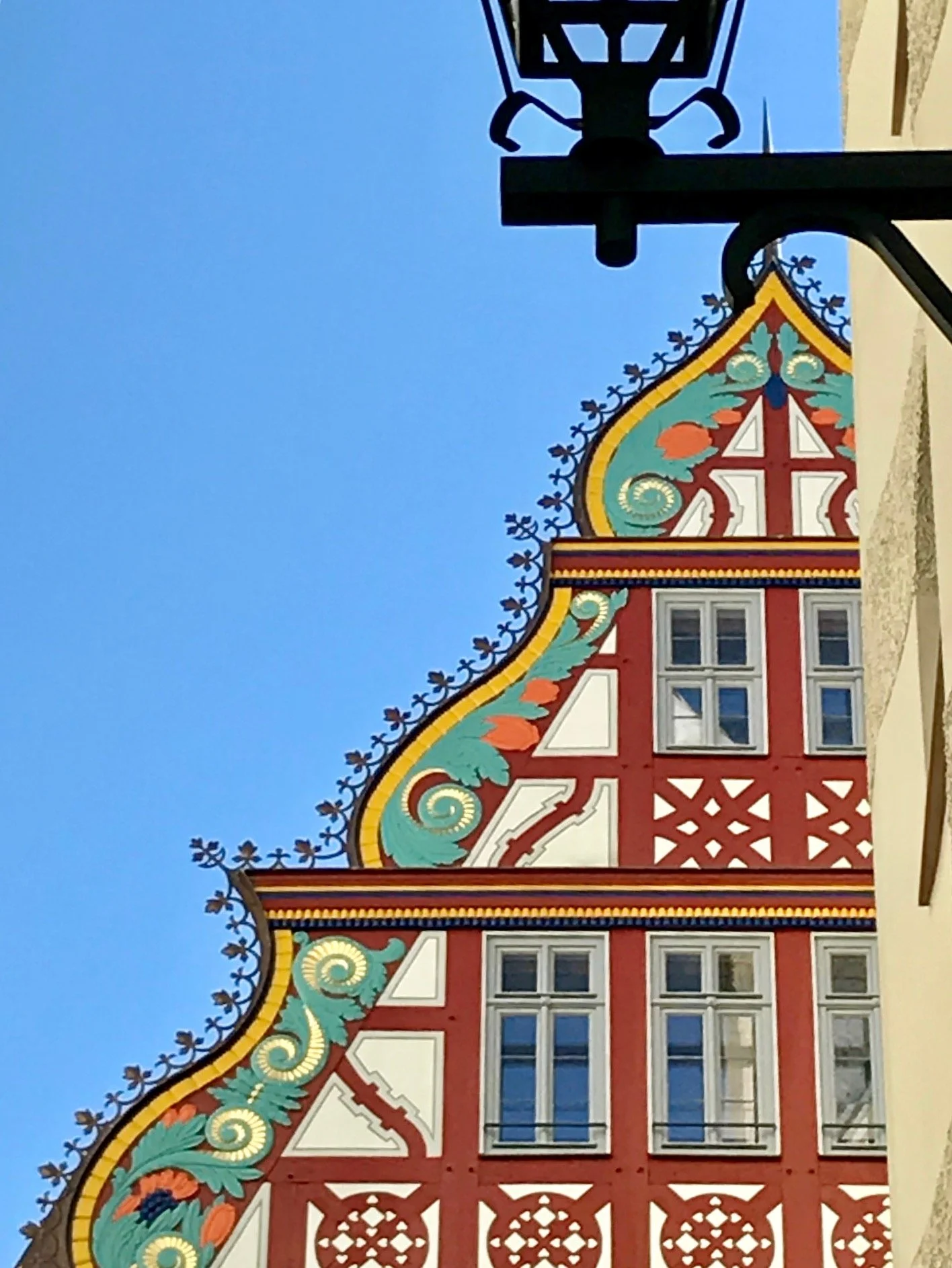 Goldener Waage house in Frankfurt. Renaissance, half timbered colorful building with decorative patterns and windows, against a clear blue sky.