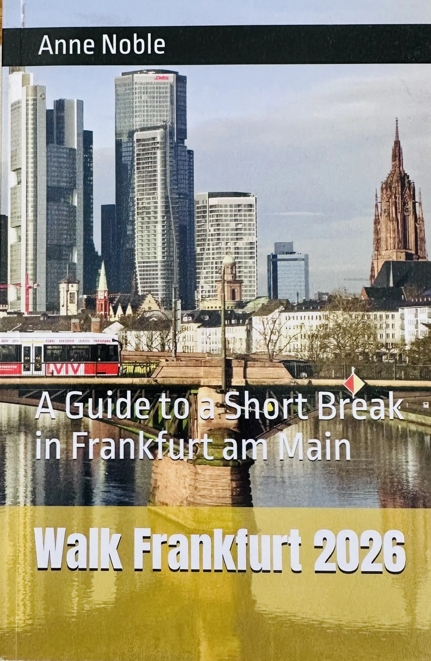 Cover of a guidebook titled 'A Guide to a Short Break in Frankfurt am Main,' featuring a cityscape with modern high-rise buildings, a church, a river, and a bridge.