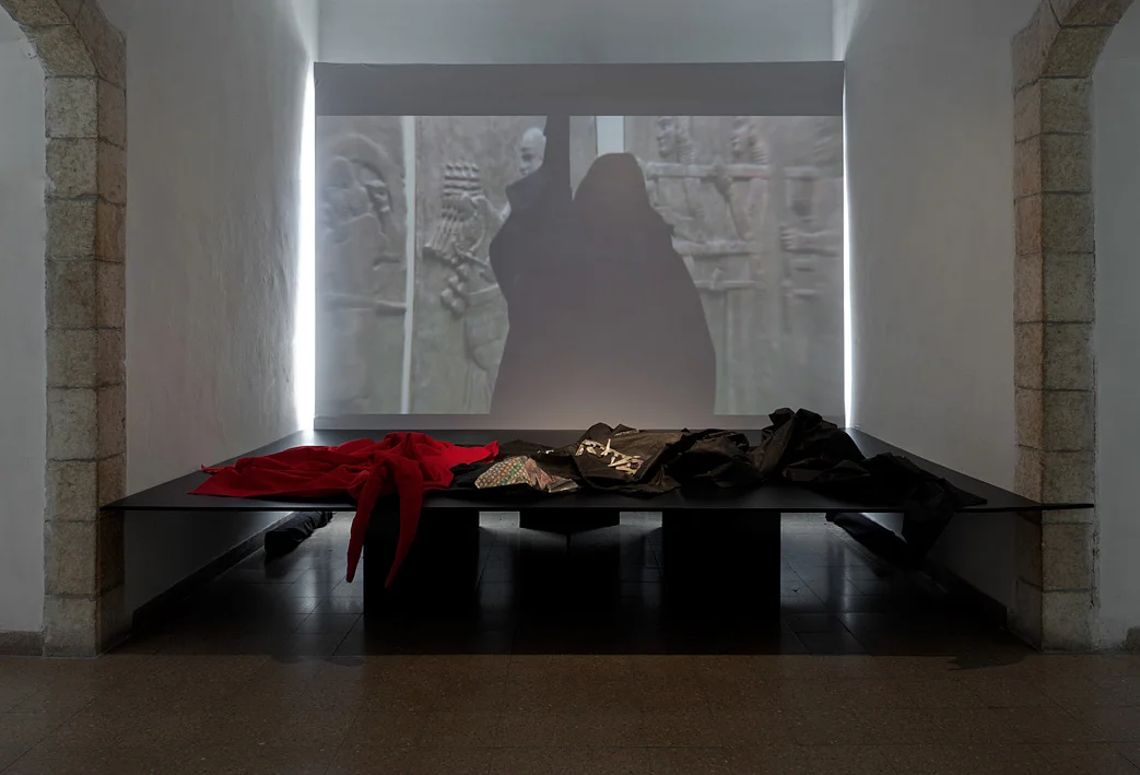 Extract from the movie SION 2002-07. On the table, dress from he movies UNIVERSES 1998-02 and SION 2002-07. Ad_Dress: Thoughts On Garments, Curator: Sophia Dekel-Caspi, The Artists House, Jerusalem 2011 Photographer: Elad Sarig