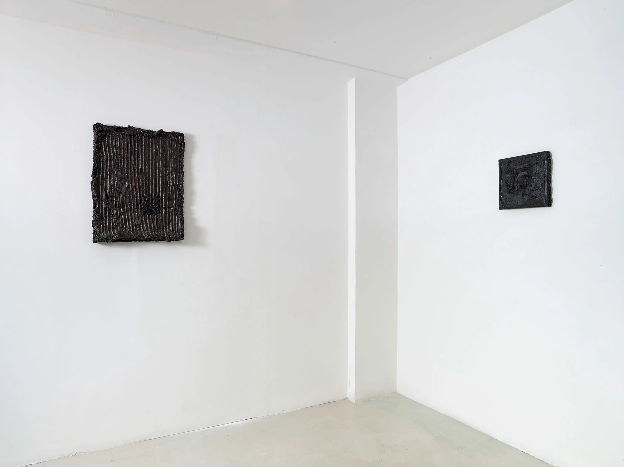 Black Box, 2016 - 2017 Série de 6 hybrides. Goudron siliconé, caoutchouc, lave noire, acrylique sur toile Dimensions variables Les boîtes noires se métamorphosent en échantillons de revêtement de murs réalisés avec des matériaux de maçonnerie, des appareils électroniques, ou des minéraux. Elles évoquent la chambre noire et le goudron que Nicéphore Niepce utilisait pour l’héliographie, l’ancêtre de la photograhie. © François Fernandez