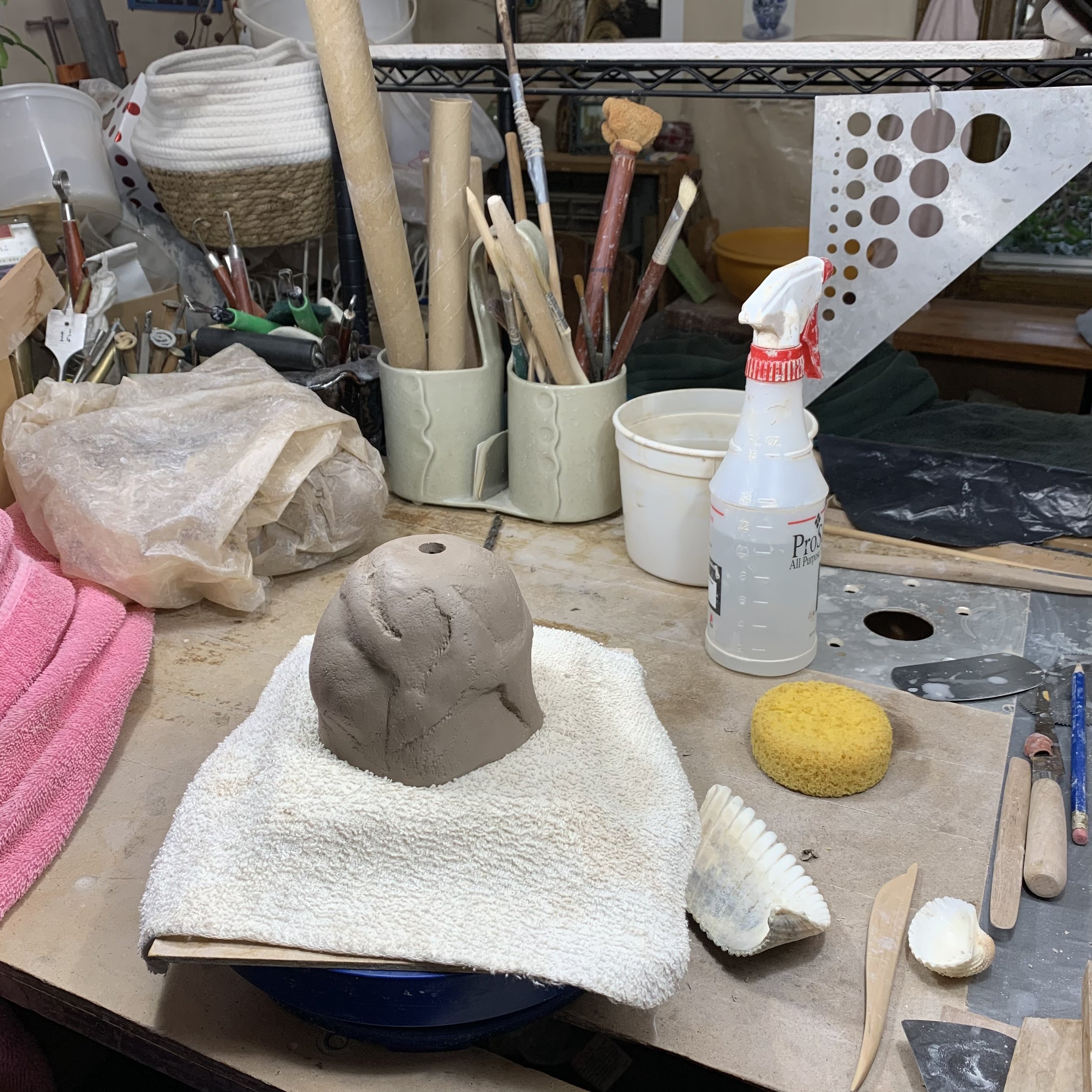 Susan prefers to use her hands as her primary tools (she does not use a potter's wheel!). Textured surfaces are created by impressing the clay onto objects from nature and woodblock printing type boards which she carves with hand tools and a dremel.