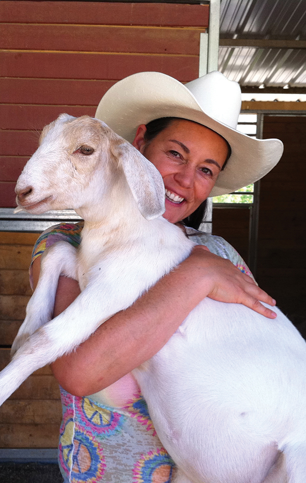 Ellie with Pixie, an orphaned goat who has found a home at the Gentle Barn.