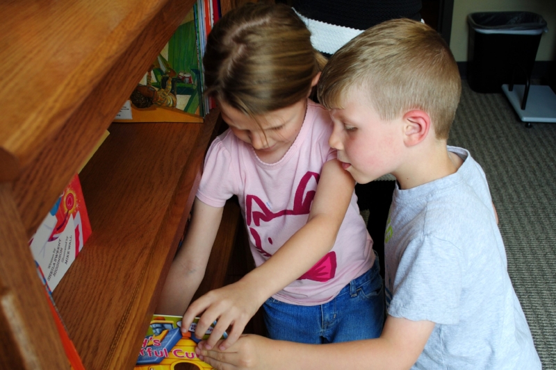 Two children check out the books in Domestic Violence Intervention Services (DVIS)'s library during the April 2016 dedication ceremony.