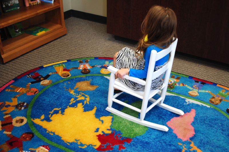 A little girl relaxes in Domestic Violence Intervention Services (DVIS)'s library during the April 2016 dedication ceremony.