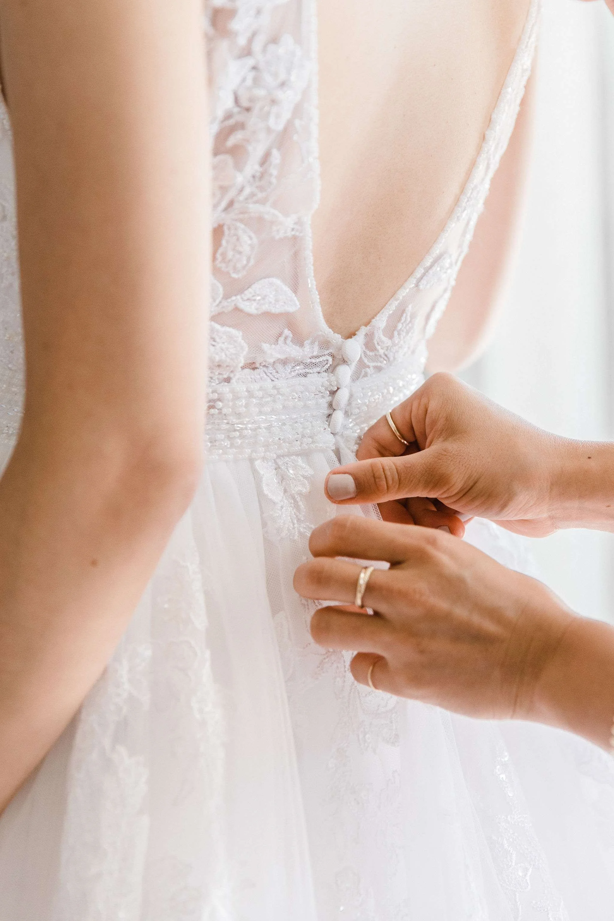 Bride putting on lace low back dress