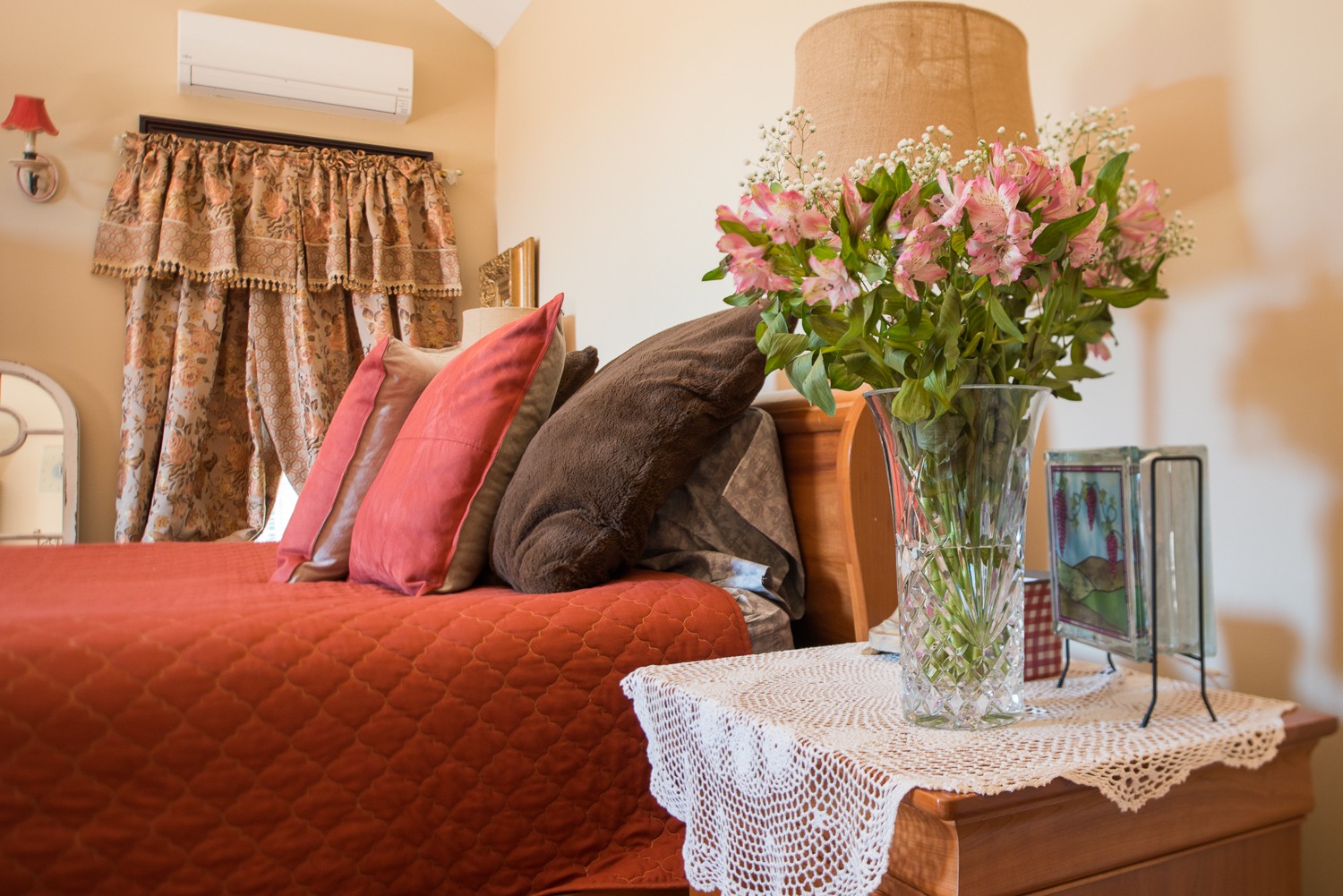 pillows on a bed with flowers on table