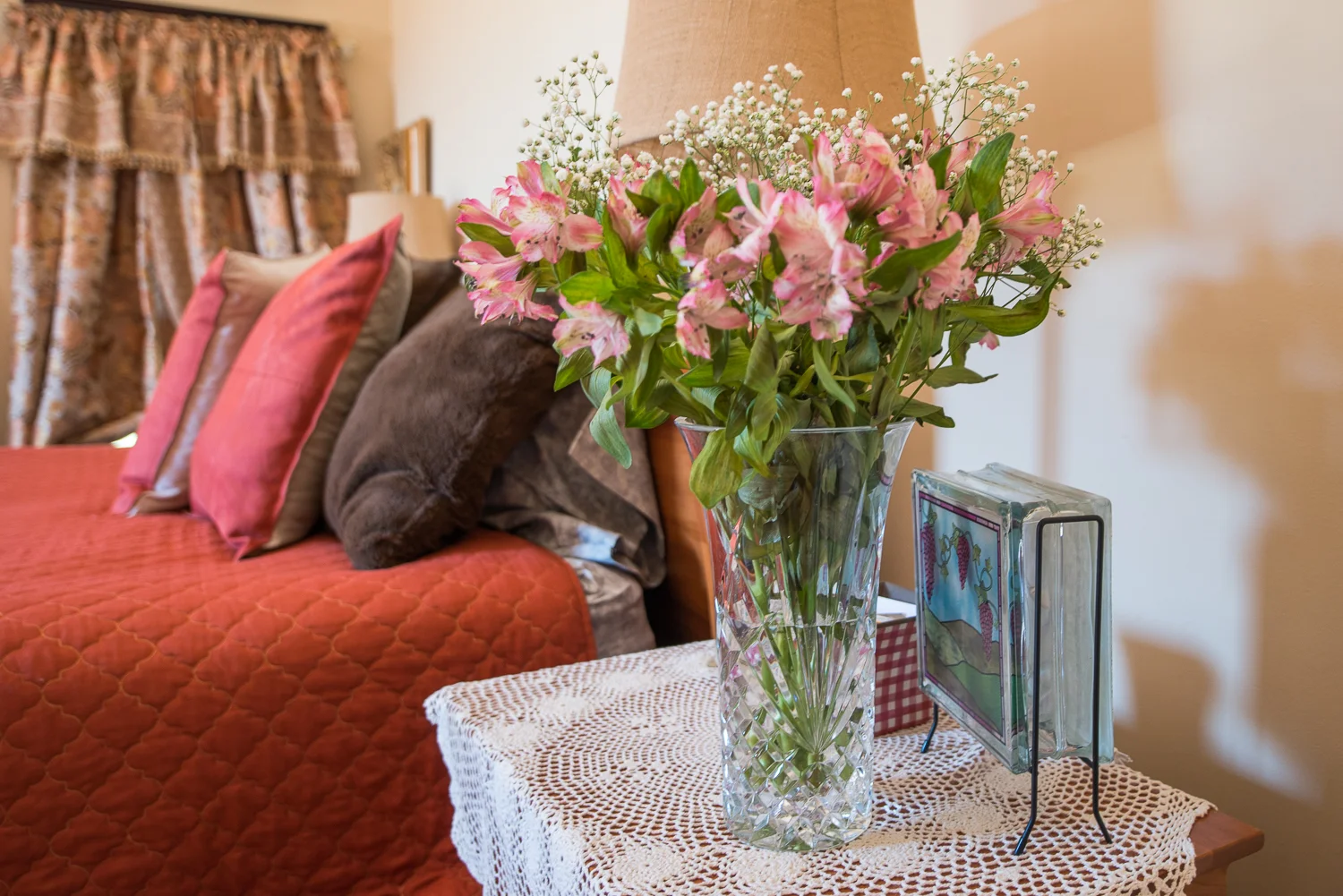 flowers on table with bed in background