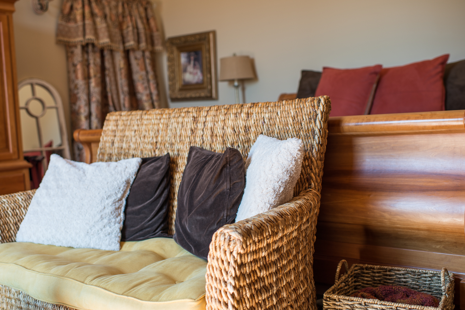 chair with pillows next to a bed