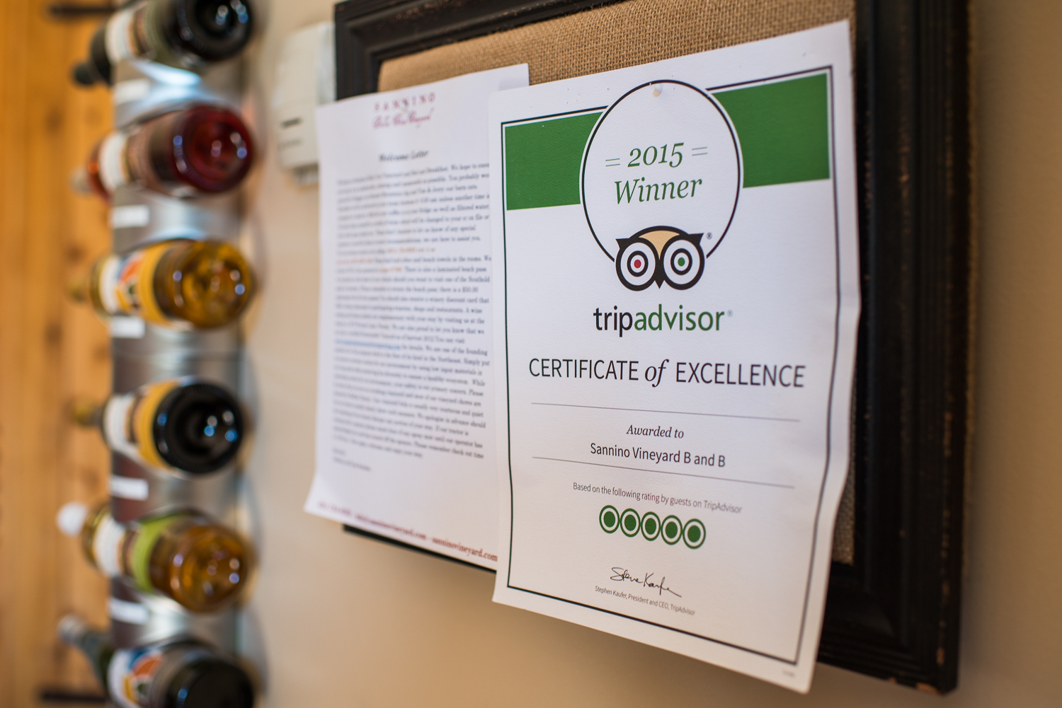 trip advisor winner certificate on wall with wine bottle in background